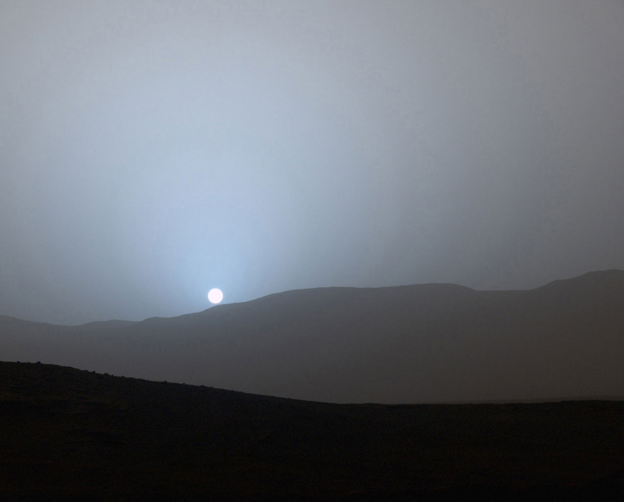 NASA's Curiosity Mars rover recorded this view of the sun setting at the close of the mission's 956th Martian day, or sol (April 15, 2015), from the rover's location in Gale Crater.This was the first sunset observed in color by Curiosity. The image comes from the left-eye camera of the rover's Mast Camera (Mastcam). The color has been calibrated and white-balanced to remove camera artifacts. Mastcam sees color very similarly to what human eyes see, although it is actually a little less sensitive to blue than people are.Dust in the Martian atmosphere has fine particles that permit blue light to penetrate the atmosphere more efficiently than longer-wavelength colors. That causes the blue colors in the mixed light coming from the sun to stay closer to sun's part of the sky, compared to the wider scattering of yellow and red colors. The effect is most pronounced near sunset, when light from the sun passes through a longer path in the atmosphere than it does at mid-day.Malin Space Science Systems, San Diego, built and operates the rover's Mastcam. NASA's Jet Propulsion Laboratory, a division of the California Institute of Technology, Pasadena, manages the Mars Science Laboratory Project for NASA's Science Mission Directorate, Washington. JPL designed and built the project's Curiosity rover.