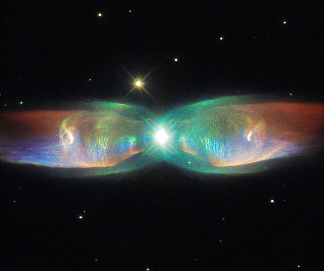The Twin Jet Nebula, or PN M2-9, is a striking example of a bipolar planetary nebula, formed when the central object is not a single star, but a binary system. An earlier image of the Twin Jet Nebula using data gathered by Hubble’s Wide Field Planetary Camera 2 was released in 1997. This newer version released on Aug. 26, 2015 incorporates more recent observations from the telescope’s Space Telescope Imaging Spectrograph.