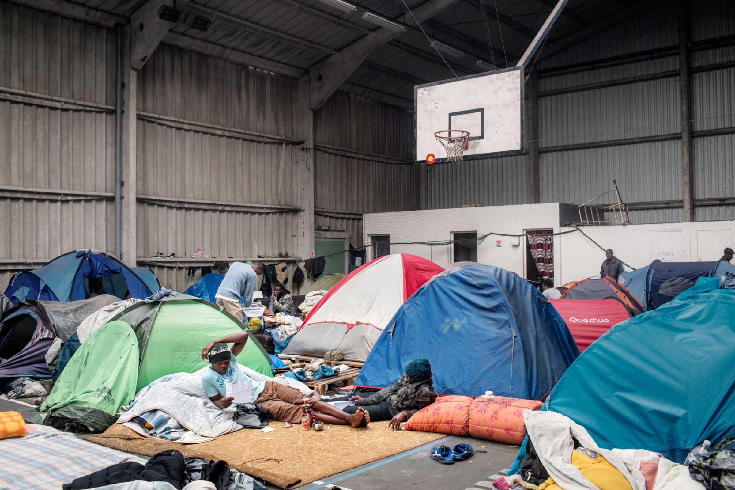 A settlement for refugees called the “Jungle,” in Calais, France, 2014. Migrants of different nationalities arrived in Calais, a port city in the northern France, in the hopes of traveling to the United Kingdom. Calais, France, 2014.