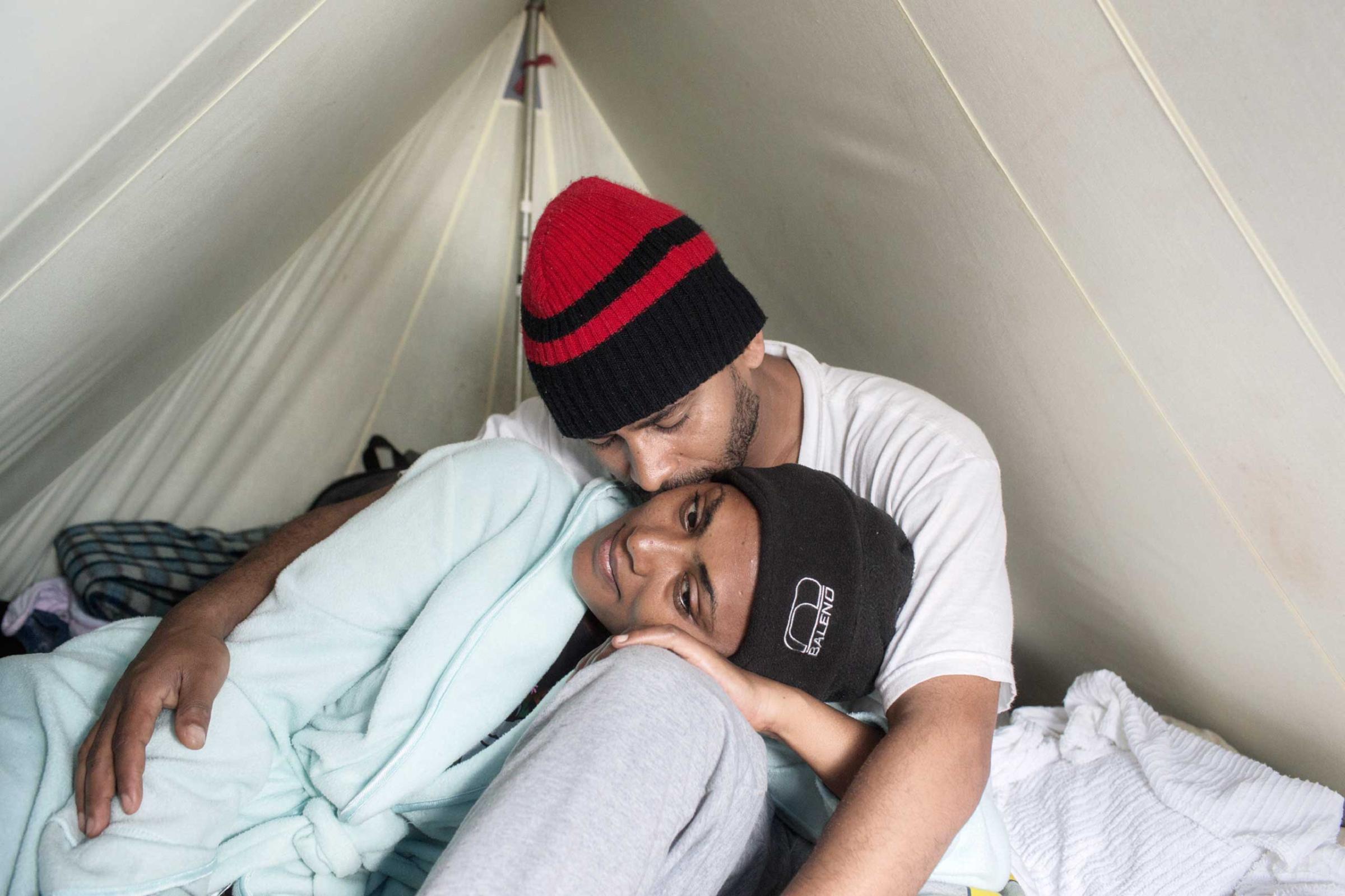 Ahmed from Ethiopia and his girlfriend “Eva” from Eritrea, who met during the journey to France and were expecting a child, resting in their tent in the “Jungle,“ a camp for refugees in Calais, France, 2014. “We met during the journey and we haven’t parted since,” said Ahmed, who hoped their child would be born in England.