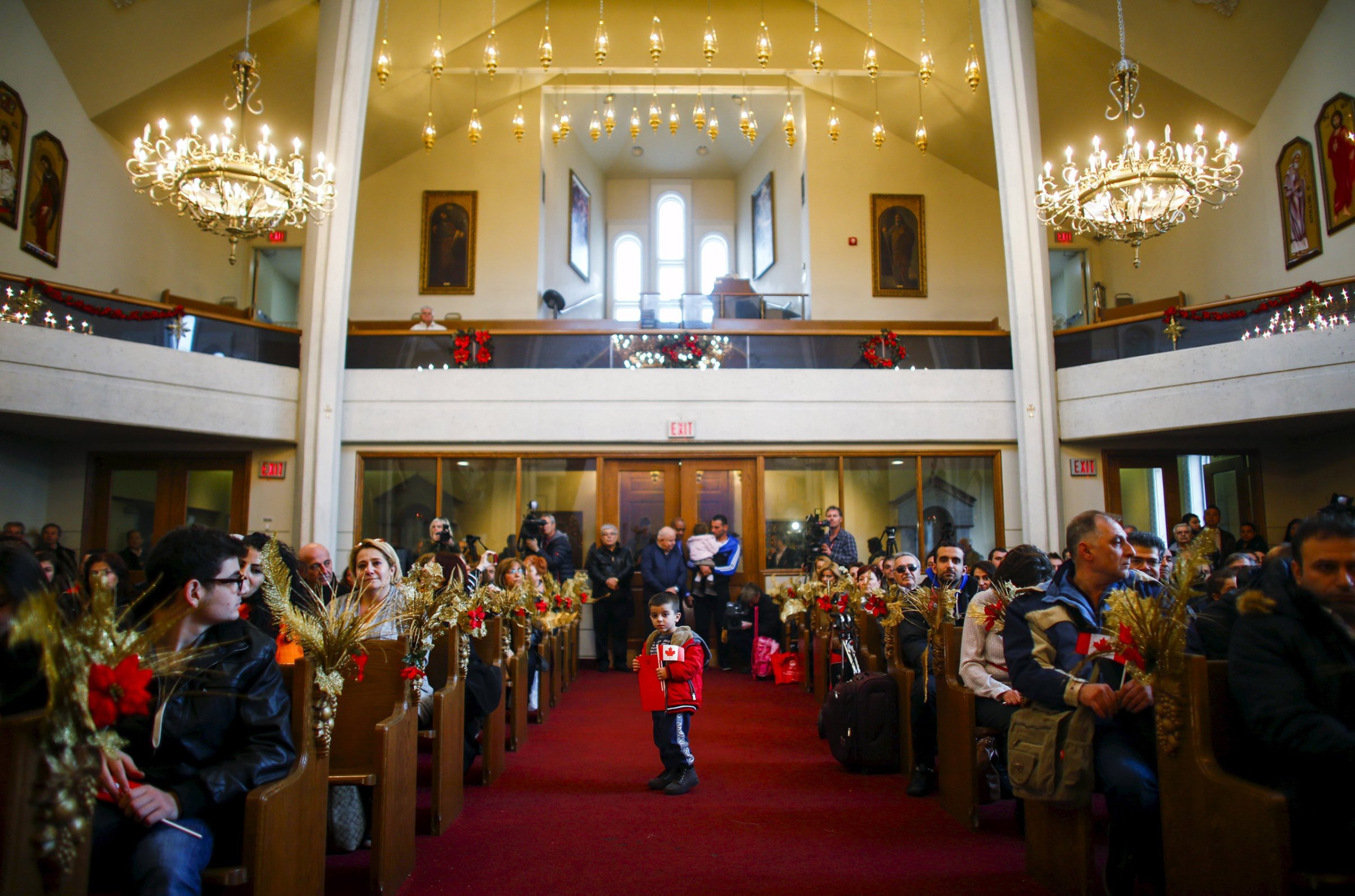 REFILE - CORRECTING CITY Syrian refugee Levon Kourken, 4, stands on an aisle during a welcoming service for Syrian refugees at St. Mary Armenian Apostolic Church at the Armenian Community Centre of Toronto in Toronto, December 11, 2015. REUTERS/Mark Blinch