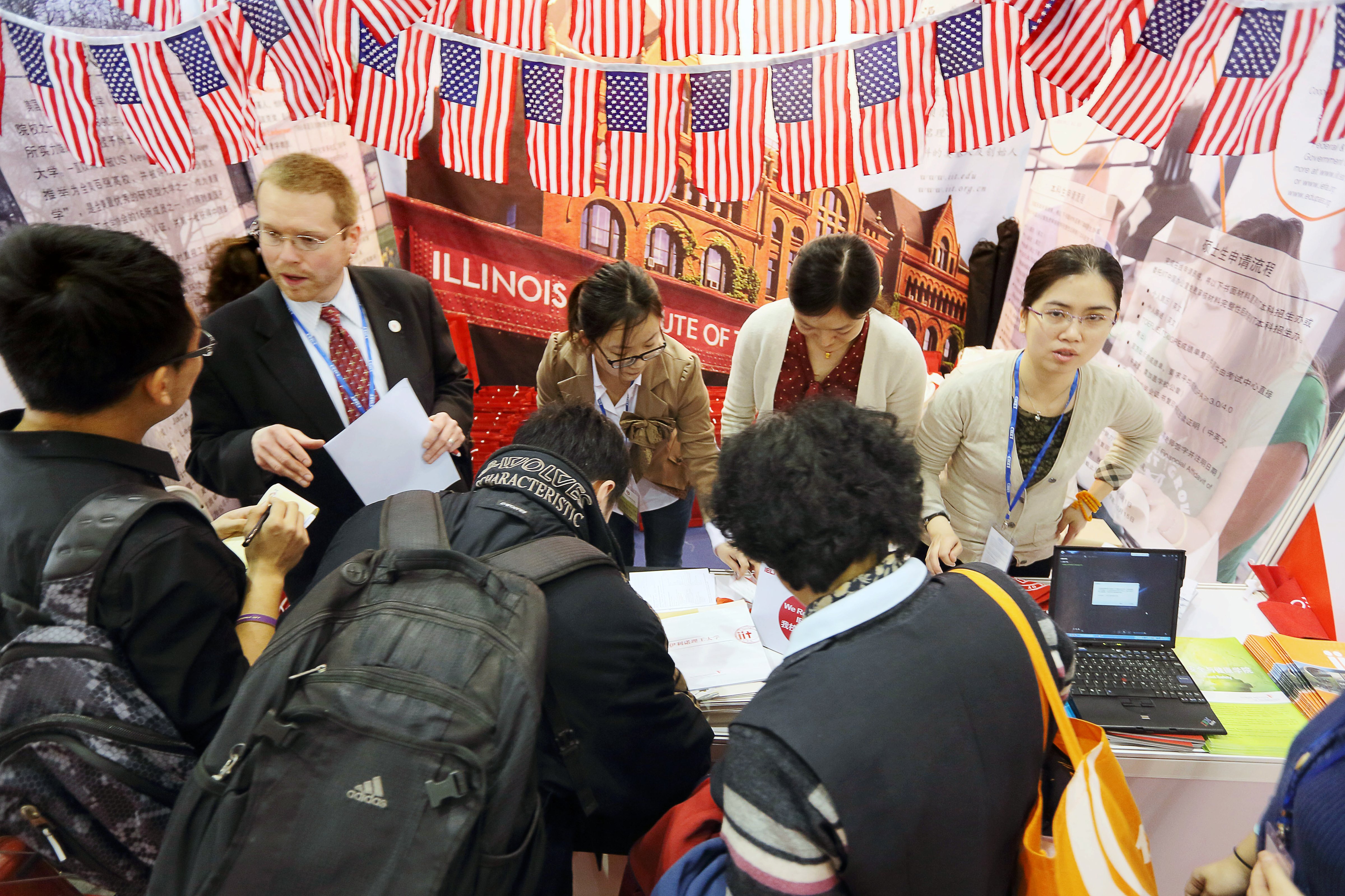 Visitors crowd the booth of an American university at the China International Education Exhibition Tour in Beijing. (Lei kesi—Imaginechina/AP)