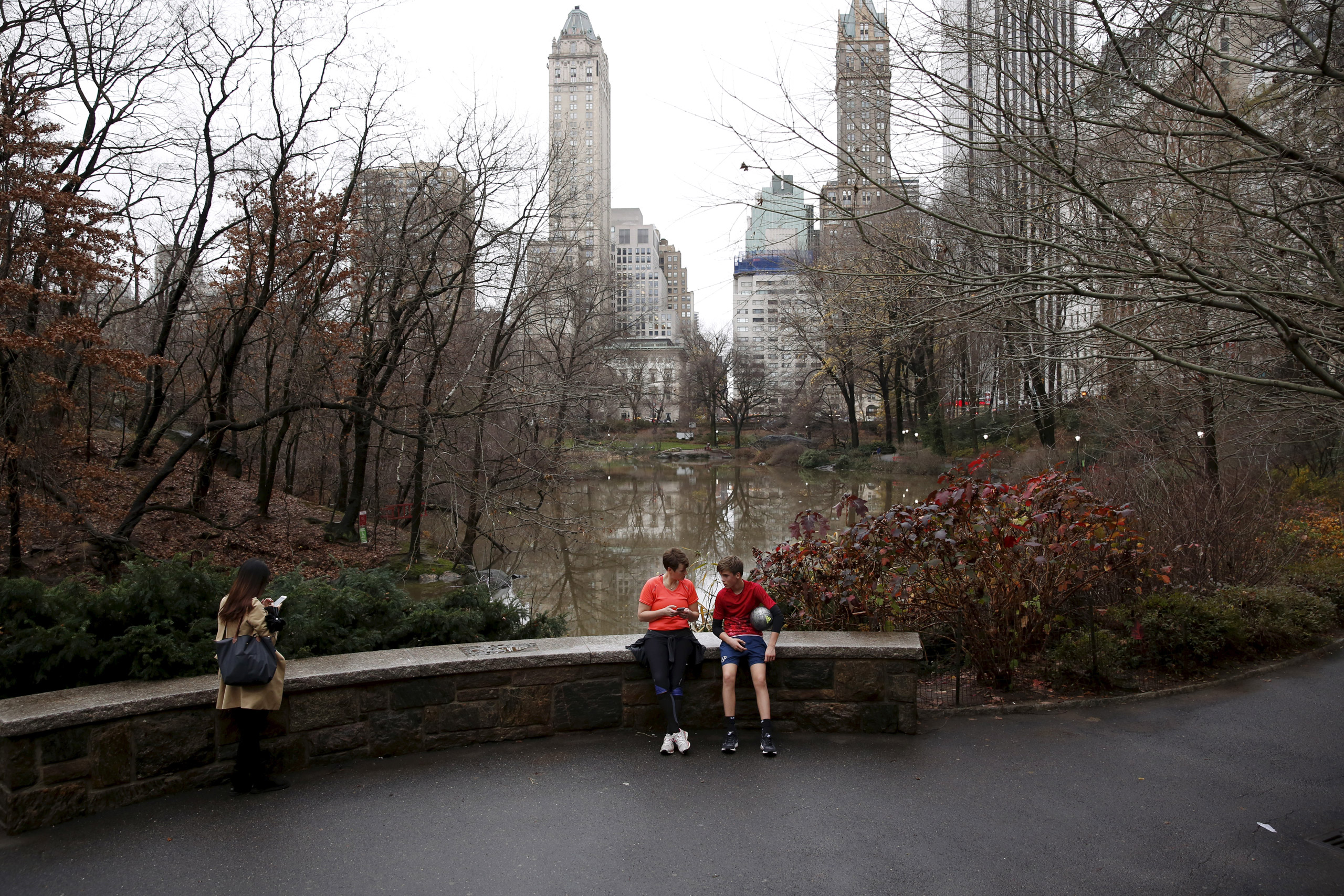 People sit to rest in Central Park during an unseasonably warm day in New York December 24, 2015. REUTERS/Lucas Jackson - RTX2005Q