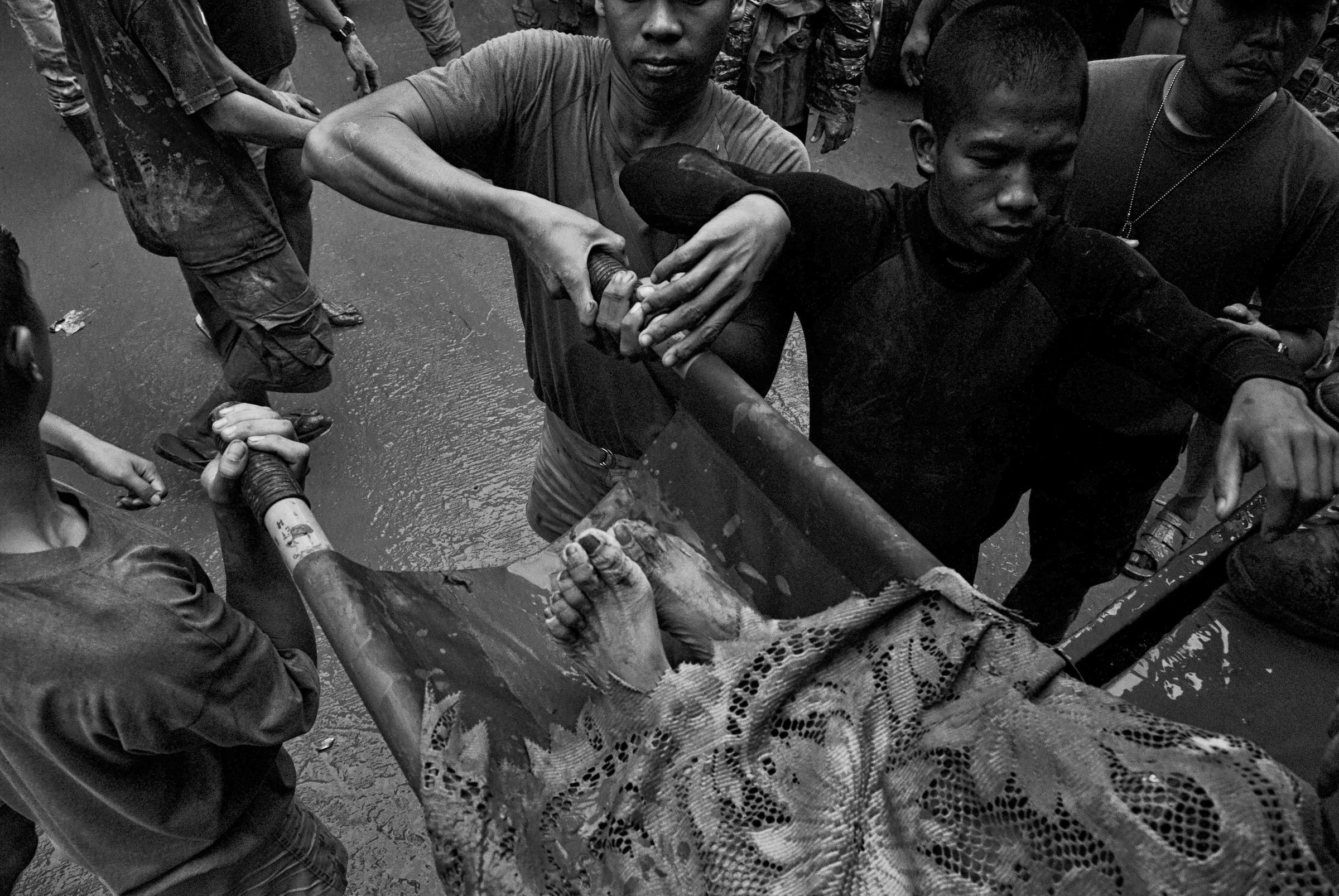 Philippine Army soldiers carry the body of a victim trapped by floodwaters in the eastern part of Metro Manila in September 2009.
