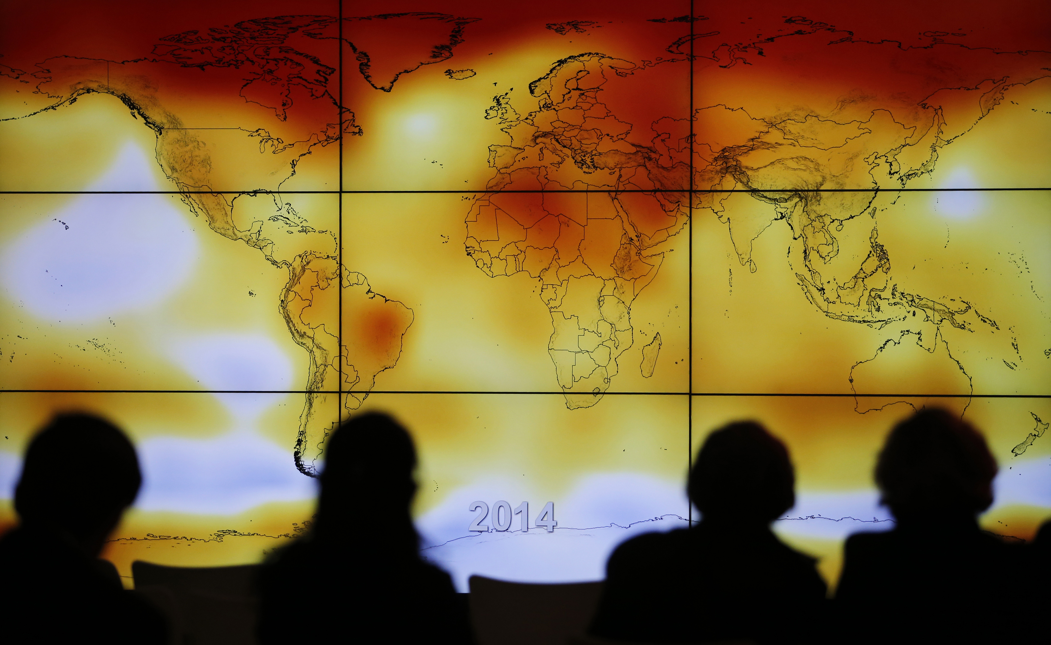 Participants are seen in silhouette as they look at a screen showing a world map with climate anomalies during the World Climate Change Conference 2015 (COP21) at Le Bourget, near Paris, Dec 8, 2015. (Stephane Mahe—Reuters)