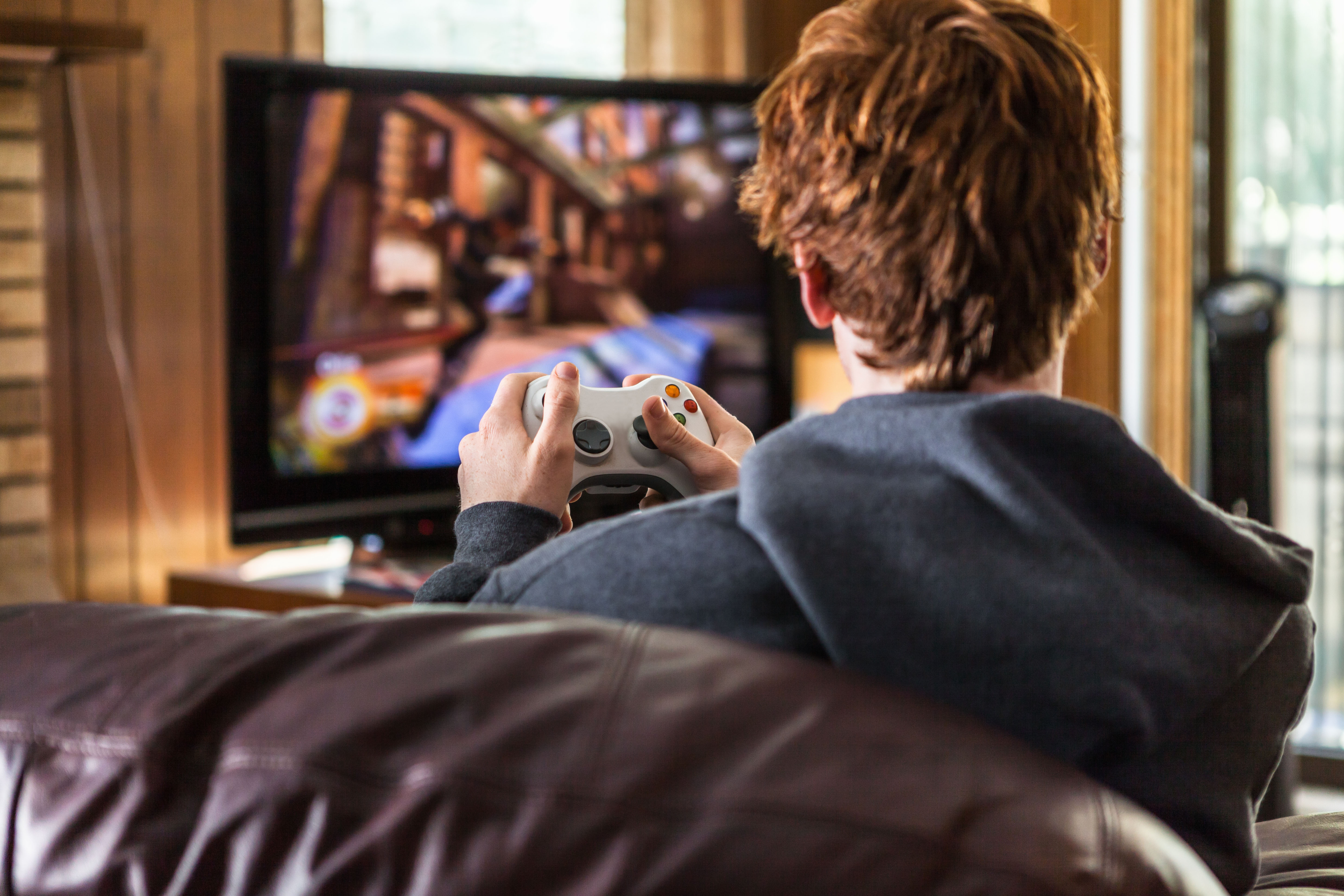 A teenager plays video games at home