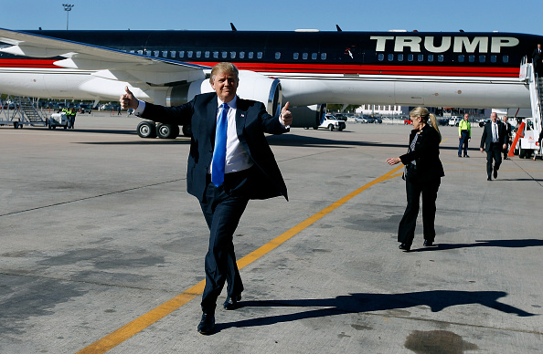 Republican presidential candidate Donald Trump gives a thumbs up to the crowd as he arrives at a campaign event at the International Air Response facility on December 16, 2015 in Mesa, Arizona.
