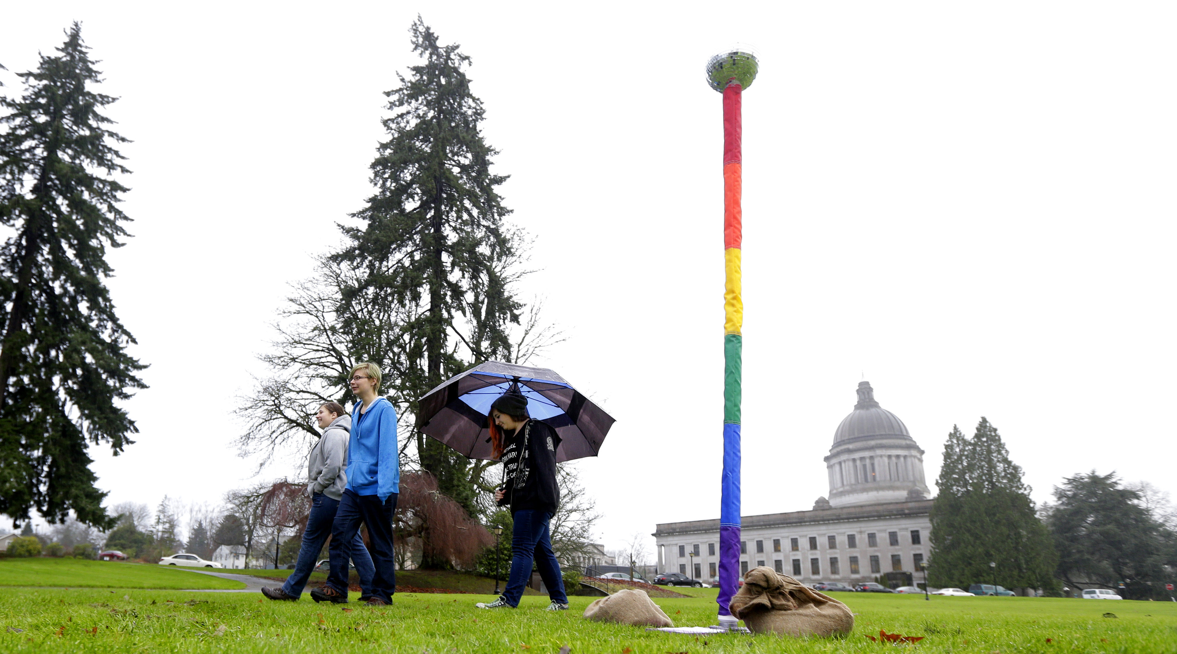 From left, siblings Kelli, Caitlynn, and Kerri Ray walk near a "Festivus Pole" supporting gay rights that they helped their father, Robert Ray, put up on Dec. 21, 2015, at the Capitol in Olympia, Wash. (Ted S. Warren—AP)