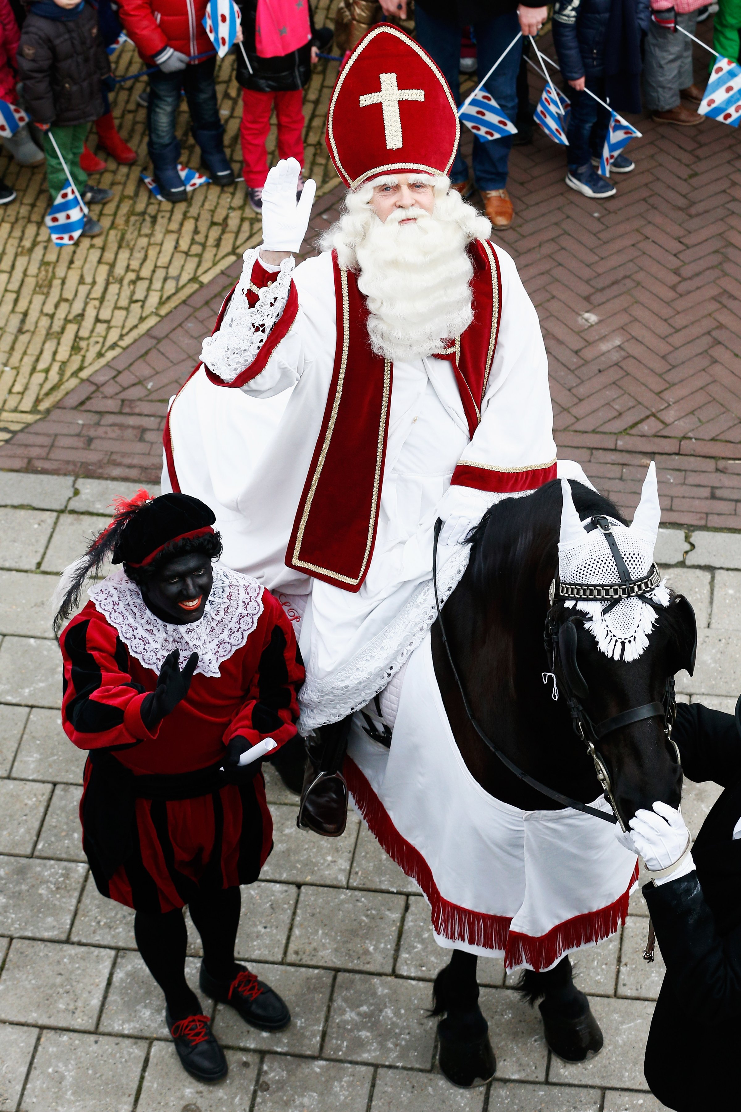 People line the streets near the pier as Sint Piter, named after the patron saint of fishermen Saint Peter, and Zwarte Piet (or Black Pete) arrive on February 14, 2015 in Grou, Netherlands.