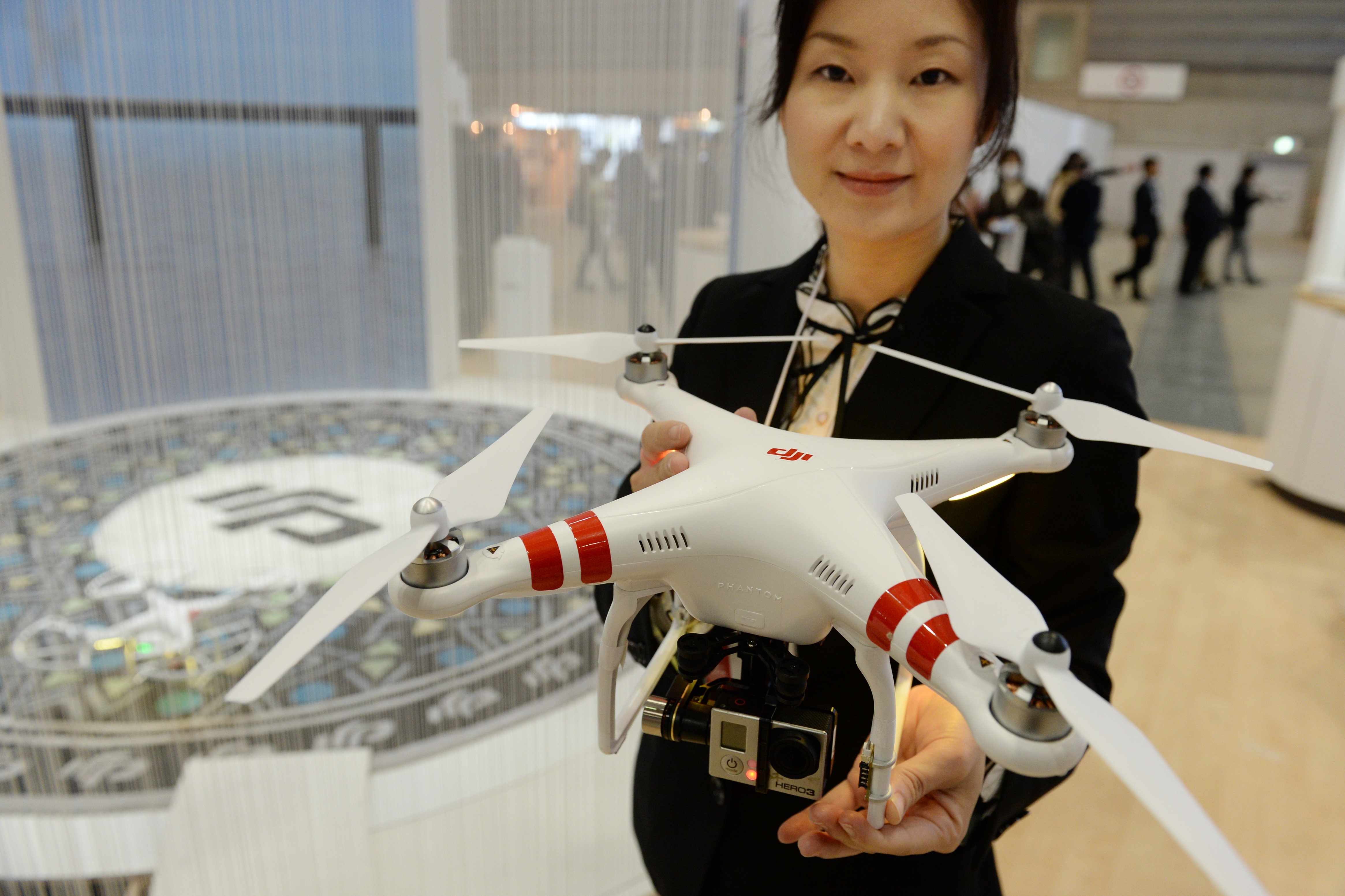 A DJI employee shows off the company's latest "Phantom 2" radio-controlled multicopter with small video camera at the DJI booth during the "CP+2014," camera and photo imaging show in Yokohama on February 13, 2014. (Toshifumi Kitamura&mdash;AFP/Getty Images)