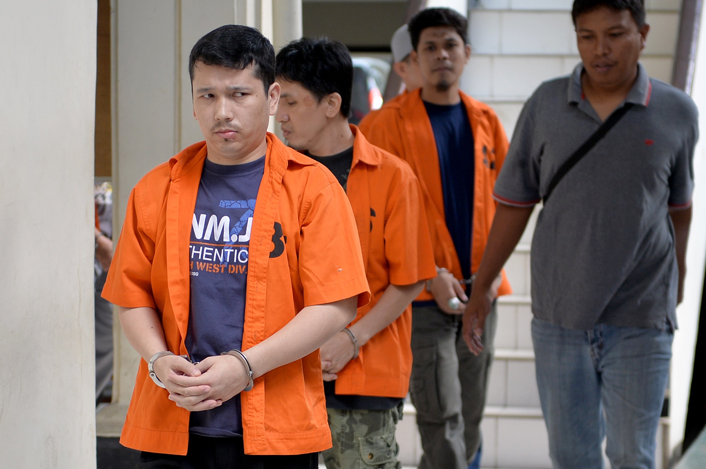 Ahmet Bozoglan, left, a member of China's Uighur minority, walks for his appearance at the North Jakarta District Court on terrorism charges on July 29, 2015, in Jakarta (Bay Ismoyo—AFP/Getty Images)