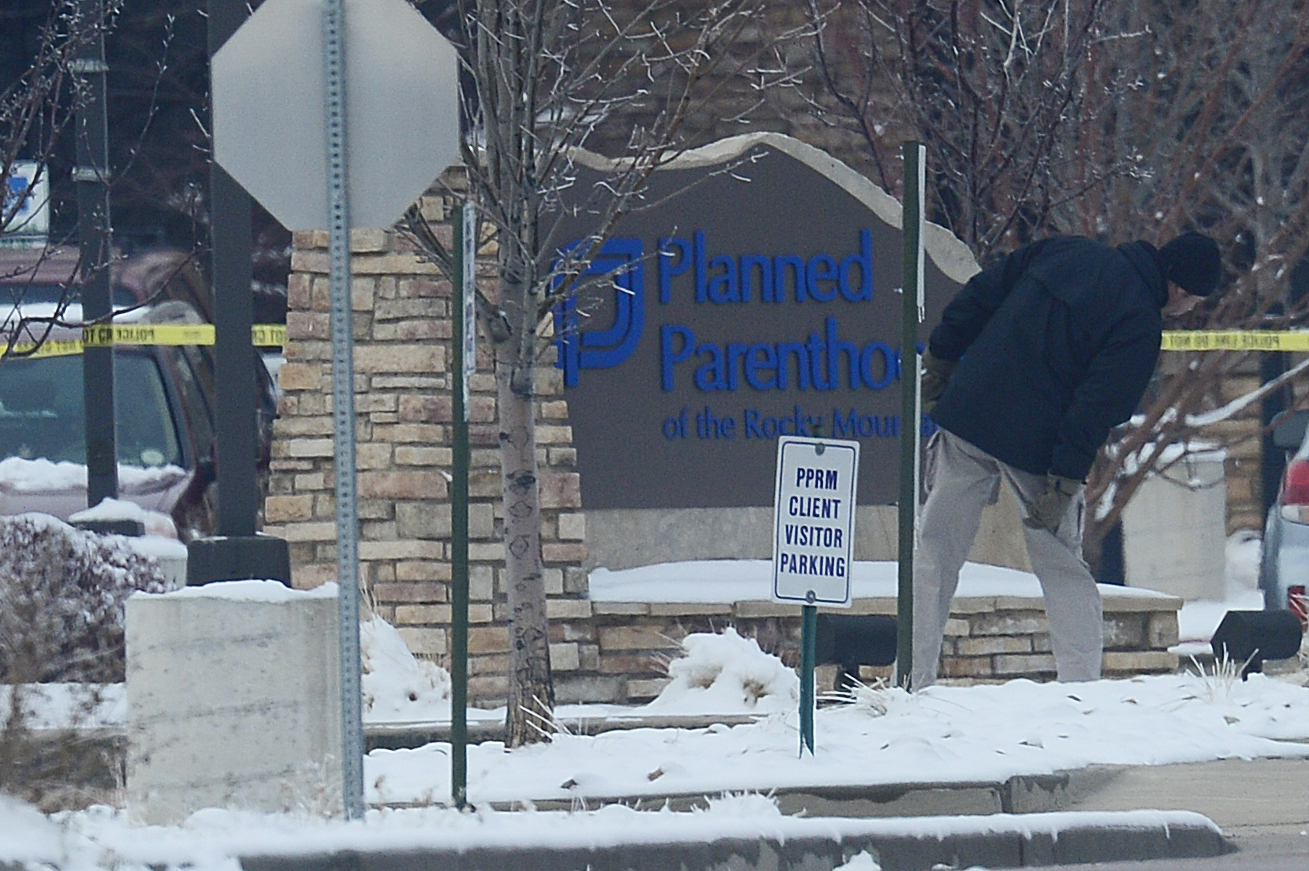 An investigator looks around the front sign of Planned Parenthood at Fillmore Street and Centennial Boulevard on November 29, 2015 in Colorado Springs, Colorado. The investigation moves into its third day after a gunman attacked a Planned Parenthood, killing three and injuring nine. (Brent Lewis—Denver Post via Getty Images)