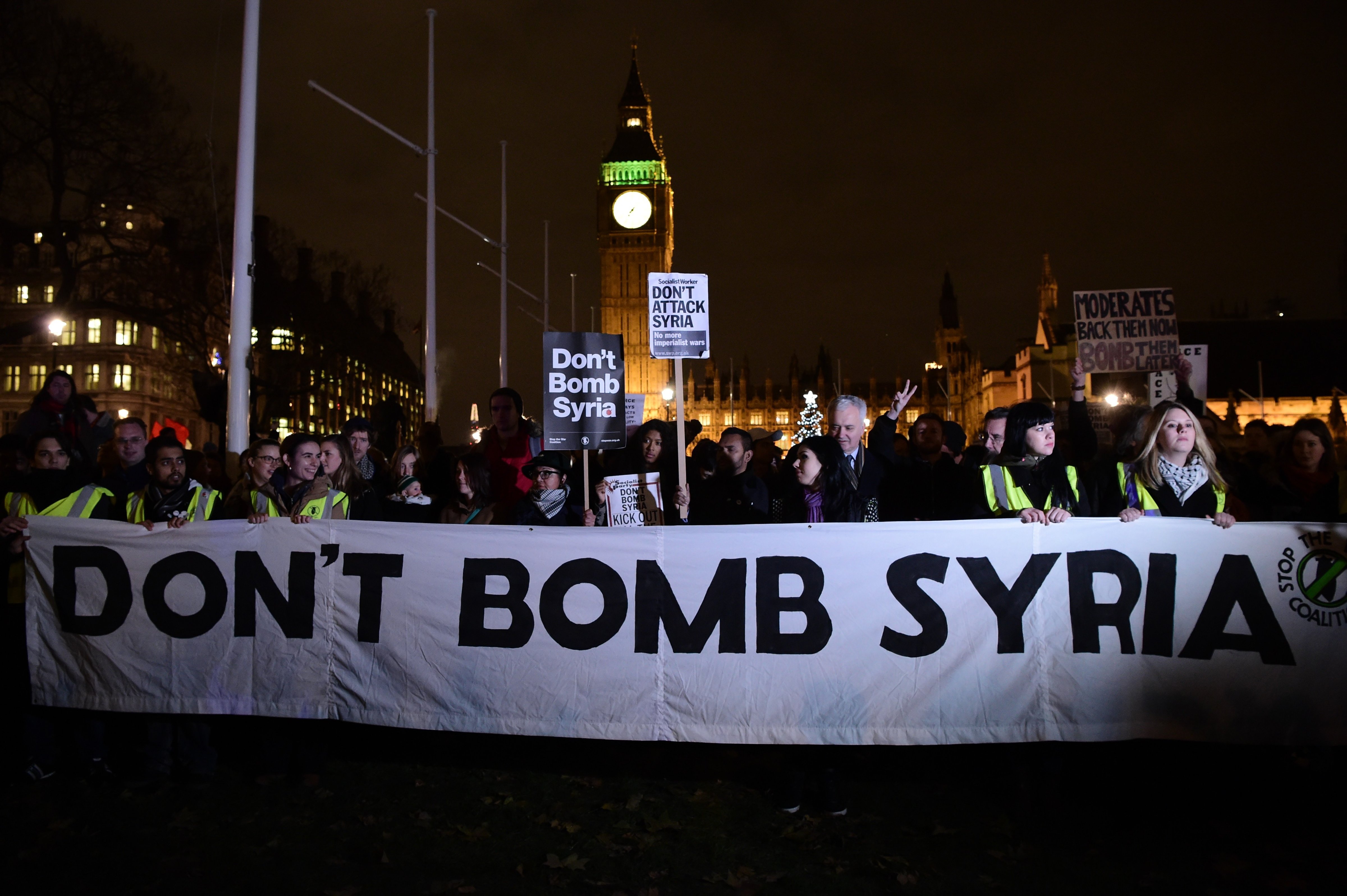Protesters stand behind a banner that reads "Don't Bomb Syria" during a demonstration against British military action in Syria outside the Houses of Parliament in London on Dec. 1, 2015 (Leon Neal—AFP/Getty Images)