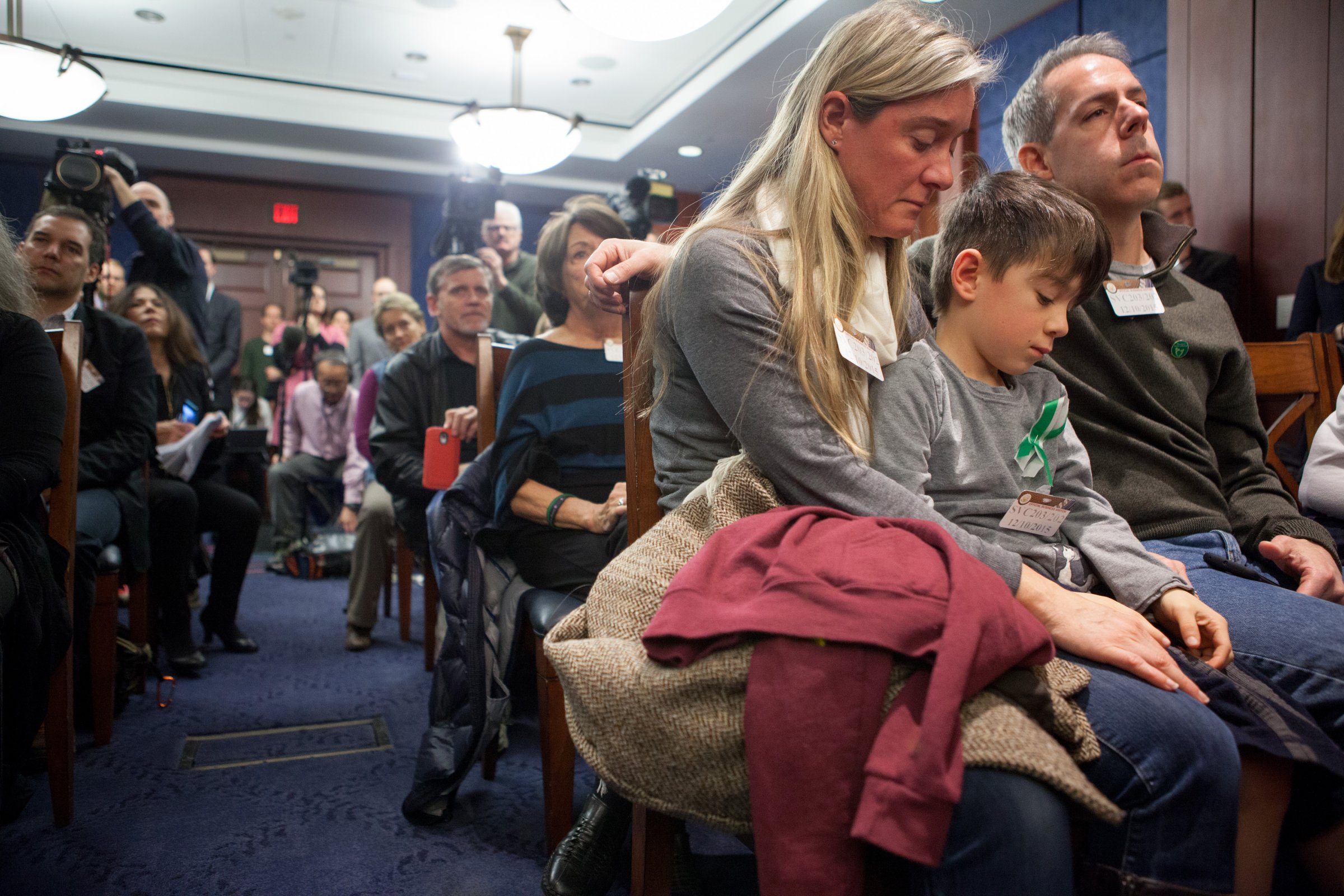 Rafe D'Agostino, 7, a second grader, sits between his parents Noelle and Paul D'Agostino during a press conference on Capitol Hill on Dec. 10.