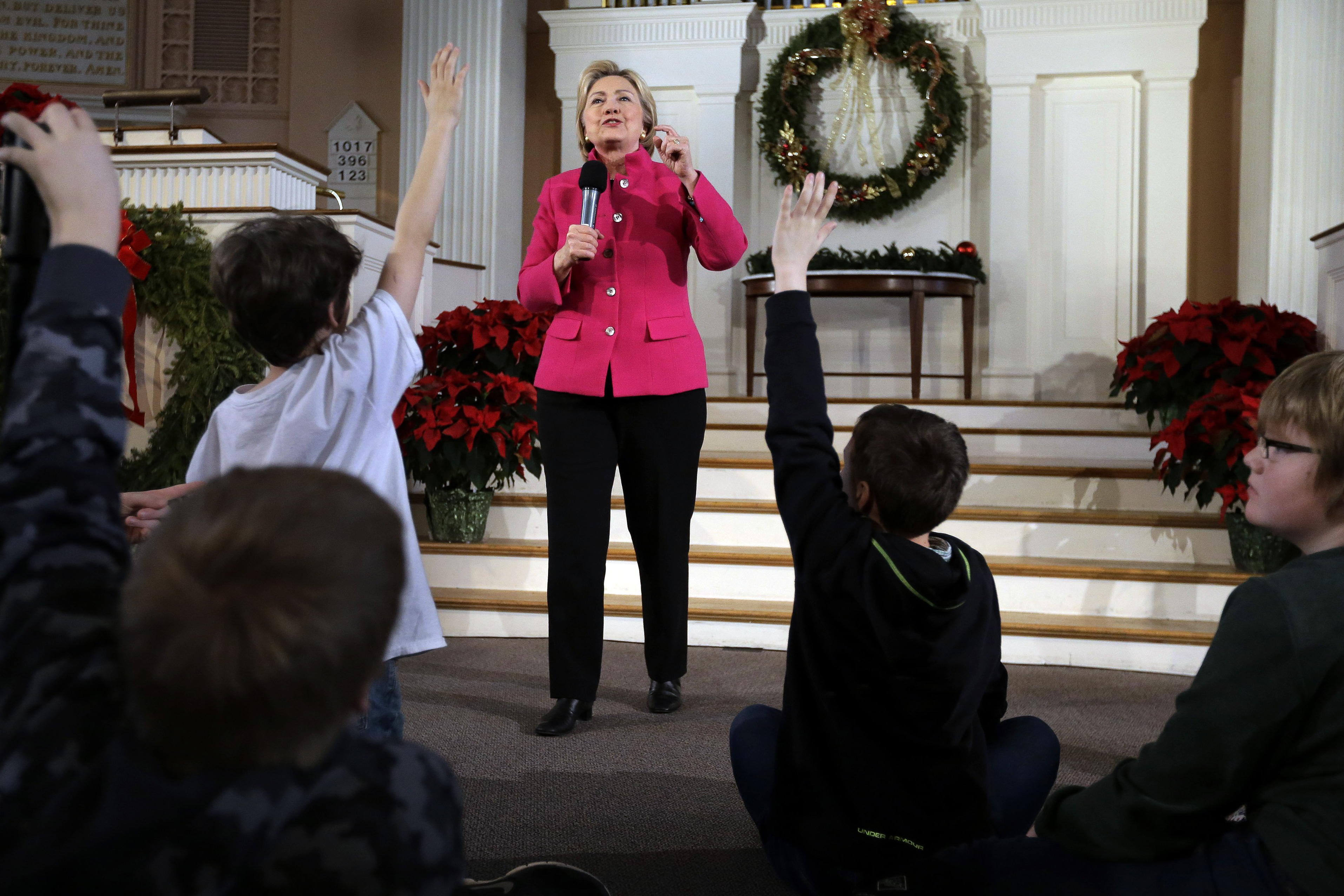 Democratic presidential candidate Hillary Clinton takes questions as children raise their hands during a town hall campaign event, Tuesday, Dec. 29, 2015, at South Church in Portsmouth, N.H. (Steven Senne—AP)