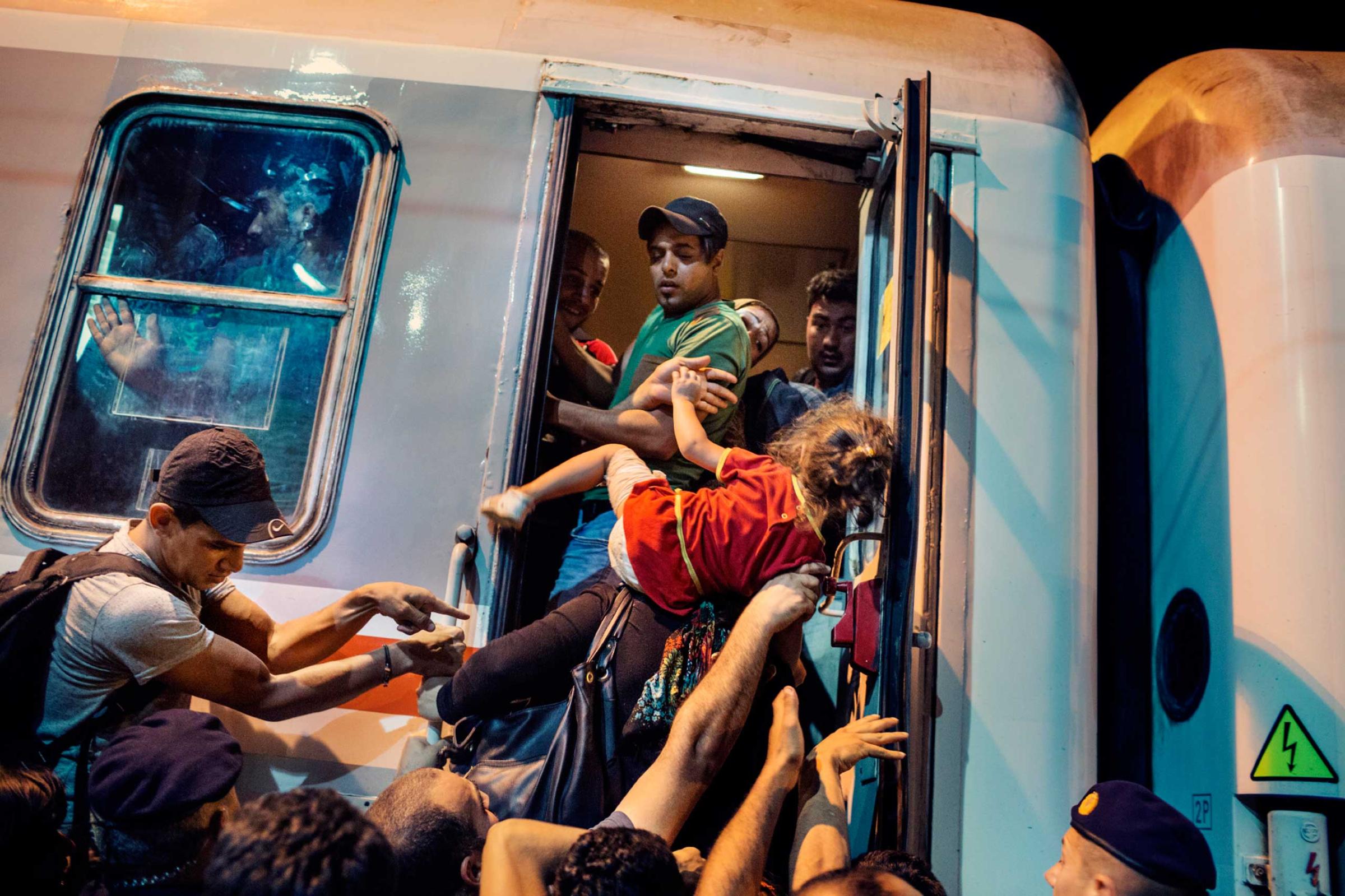Refugees, asylum seekers and migrants attempt to board a train at the Croatian town of Tovarnik, near the border with Serbia. Some have been waiting for days to catch a train and families have been separated in the chaos. Tovarnik, Croatia, Sept. 20, 2015.