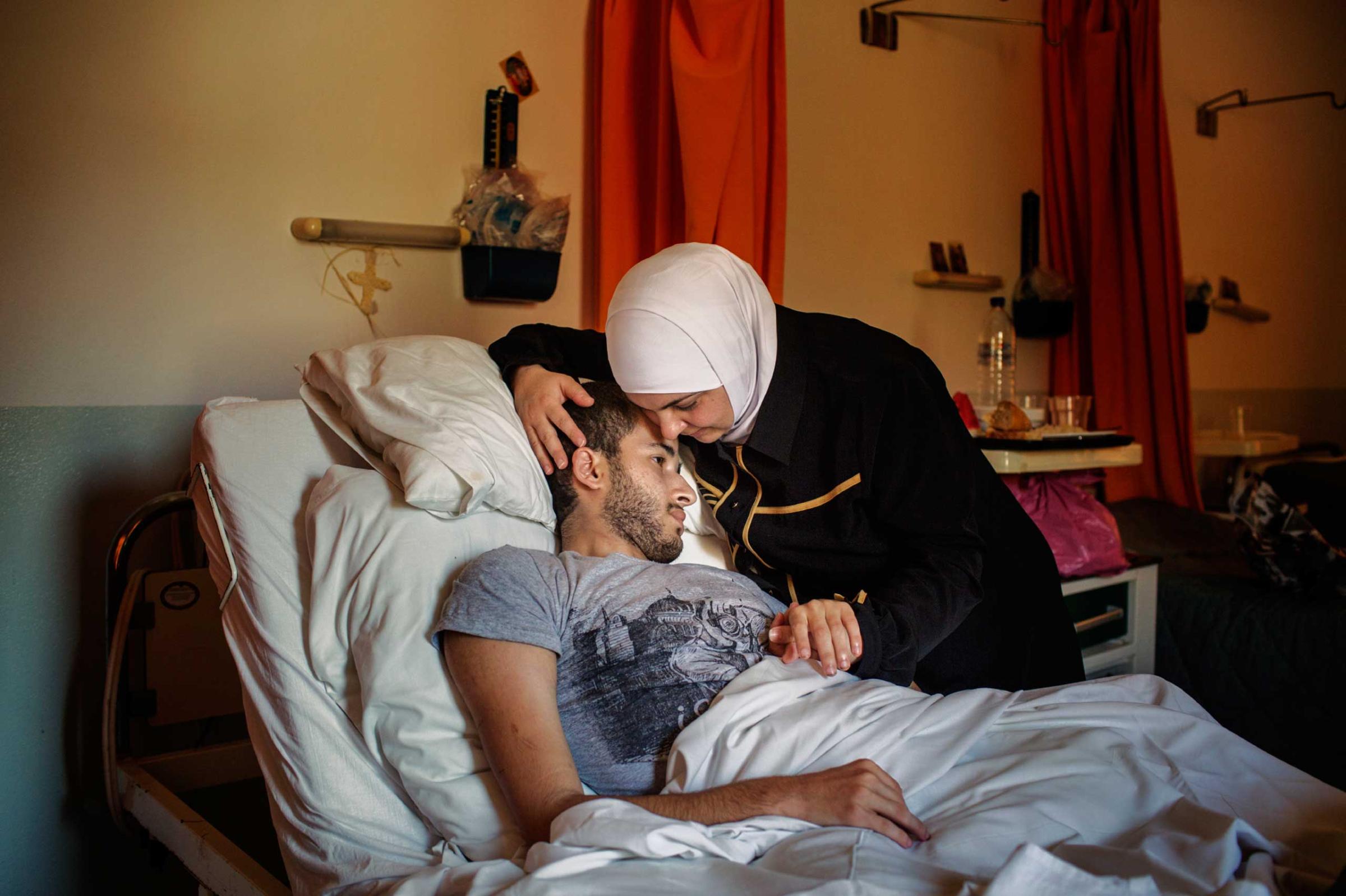 Syrian refugees, 38-year-old Ama Haider tends her 22-year-old son Khalid Hamed, who is handicapped. The family, including Haide's husband and two other children, made the arduous and risky journey from Turkey to Kos, Greece, by paying smugglers 10,000 euro, July 8, 2015.