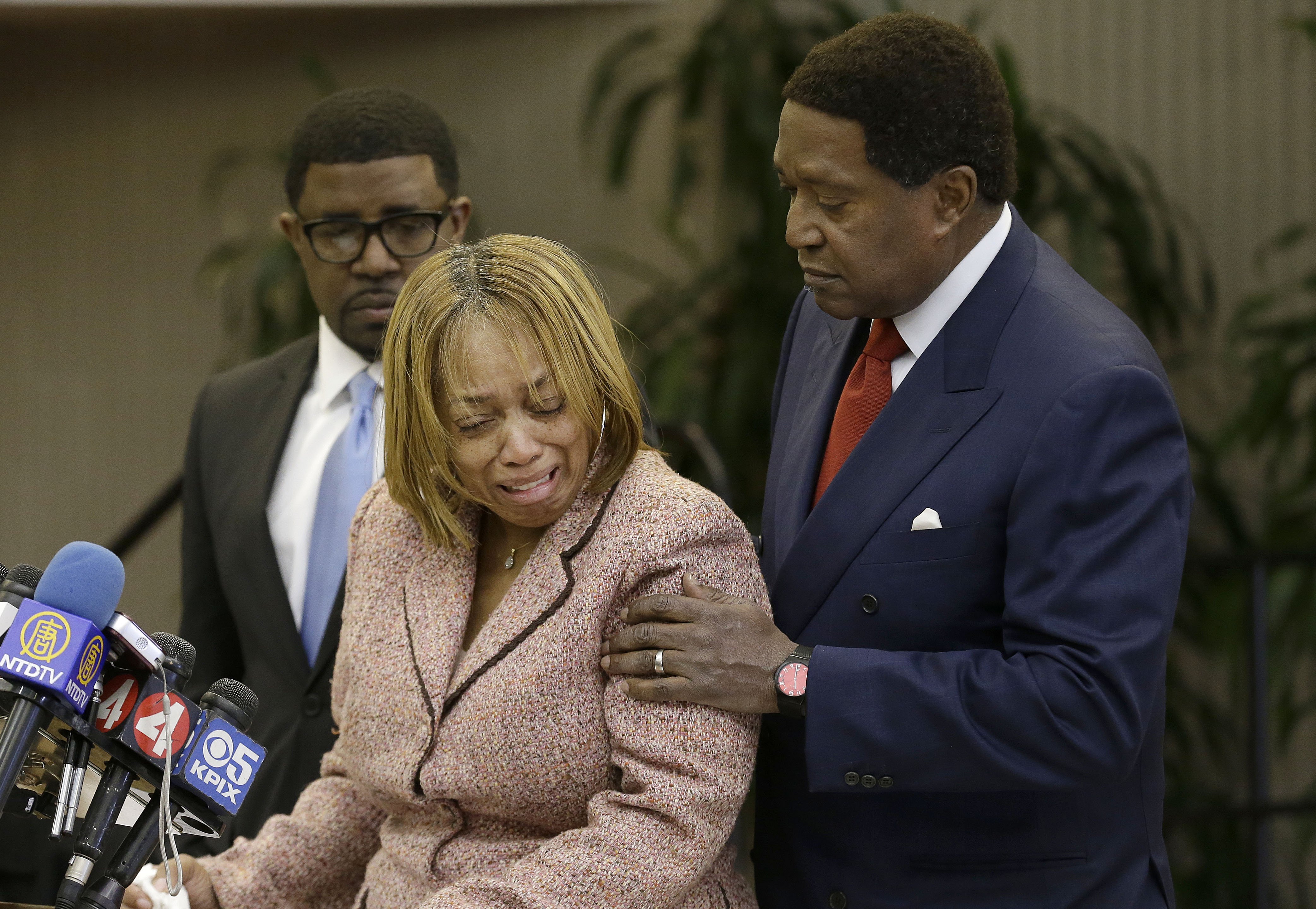 Attorney John Burris comforts Gwen Woods, the mother of Mario Woods, the suspect who was fatally shot by San Francisco Police last week, at a news conference at Southeast Community College in San Francisco on Dec. 11, 2015. (Jeff Chiu—AP)