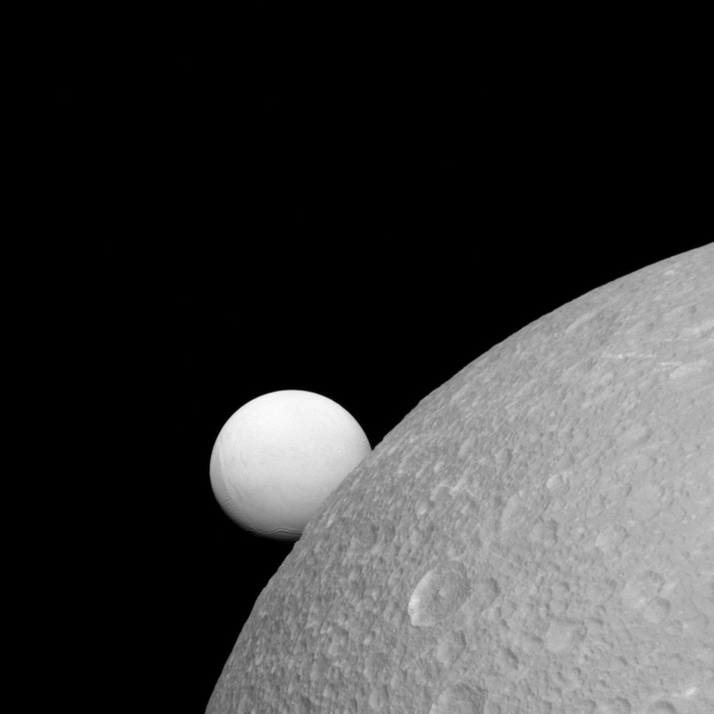 Although Dione (near) and Enceladus (far) are composed of nearly the same materials, Enceladus has a considerably higher reflectivity than Dione. As a result, it appears brighter against the dark night sky.This view looks toward the leading hemisphere of Enceladus. North on Enceladus is up and rotated 1 degree to the right. The image was taken in visible light with the Cassini spacecraft narrow-angle camera on Sept. 8, 2015.