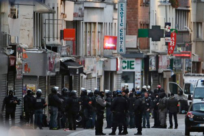 Police officers gather in the northern Paris suburb of Saint-Denis as special forces raid an apartment on Nov. 18, 2015.