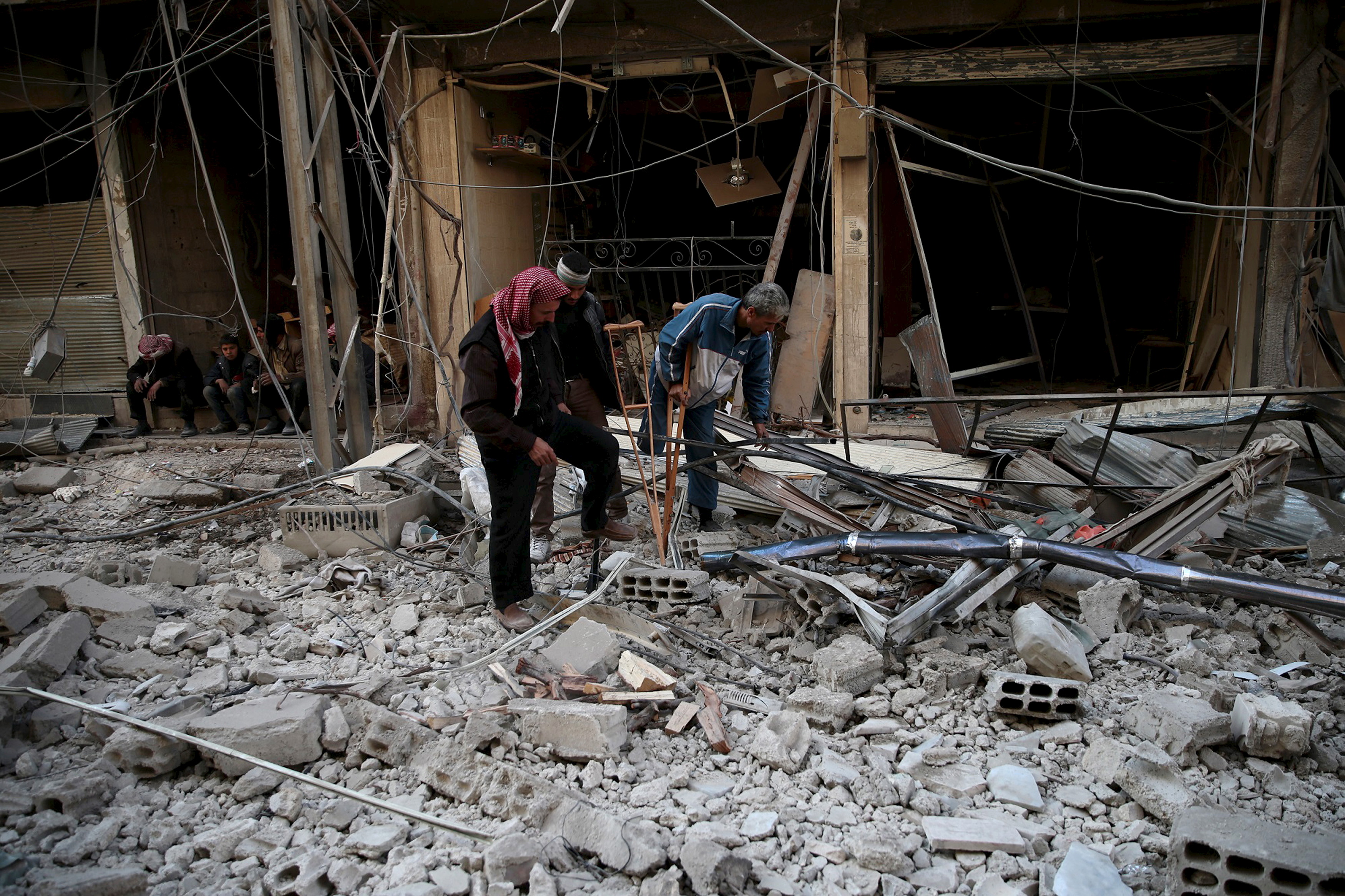 Men search for belongings at a site hit by missiles in the Douma neighborhood of Damascus on Dec. 13, 2015 (Bassam Khabieh—Reuters)