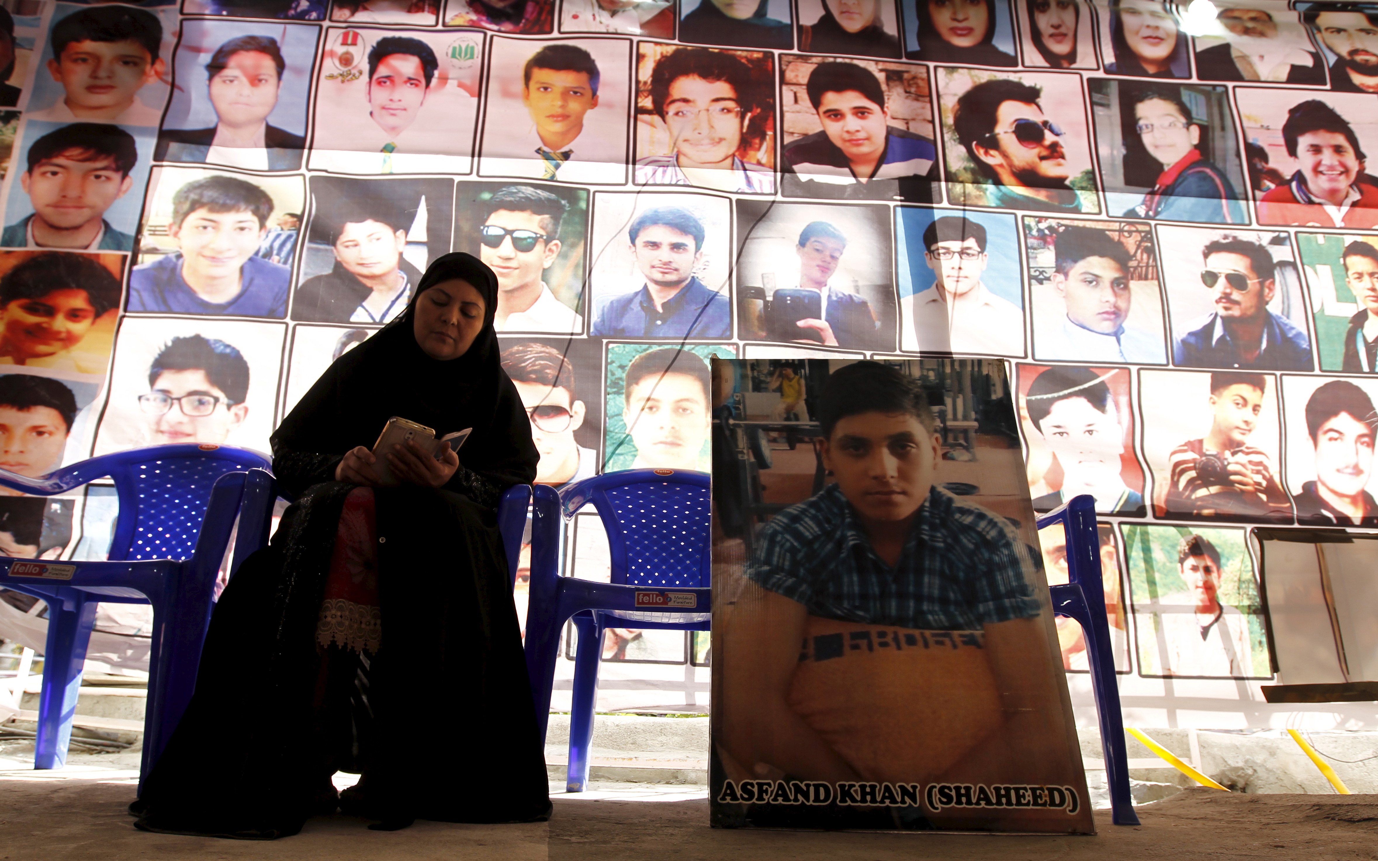 Shahana Ajoon, mother of Asfand Khan, sits beside a picture of her son in Peshawar