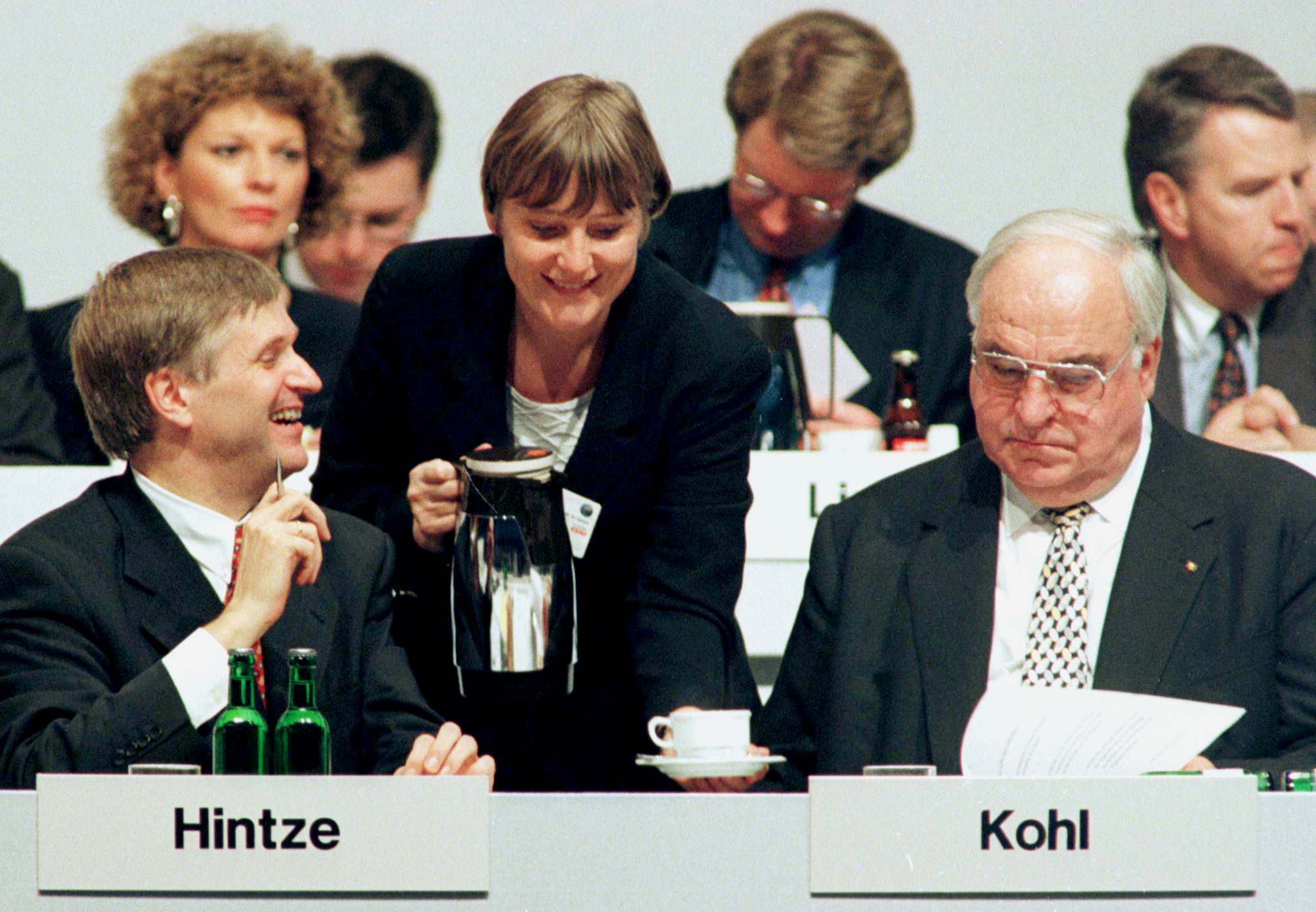 Environmental Minister Angela Merkel (C) serves some coffee as German Chancellor and CDU leader Helmut Kohl (R) and party secretary Peter Hintze (L) look on at the annual CDU (Christian Democratic Union) party congress, October 21.