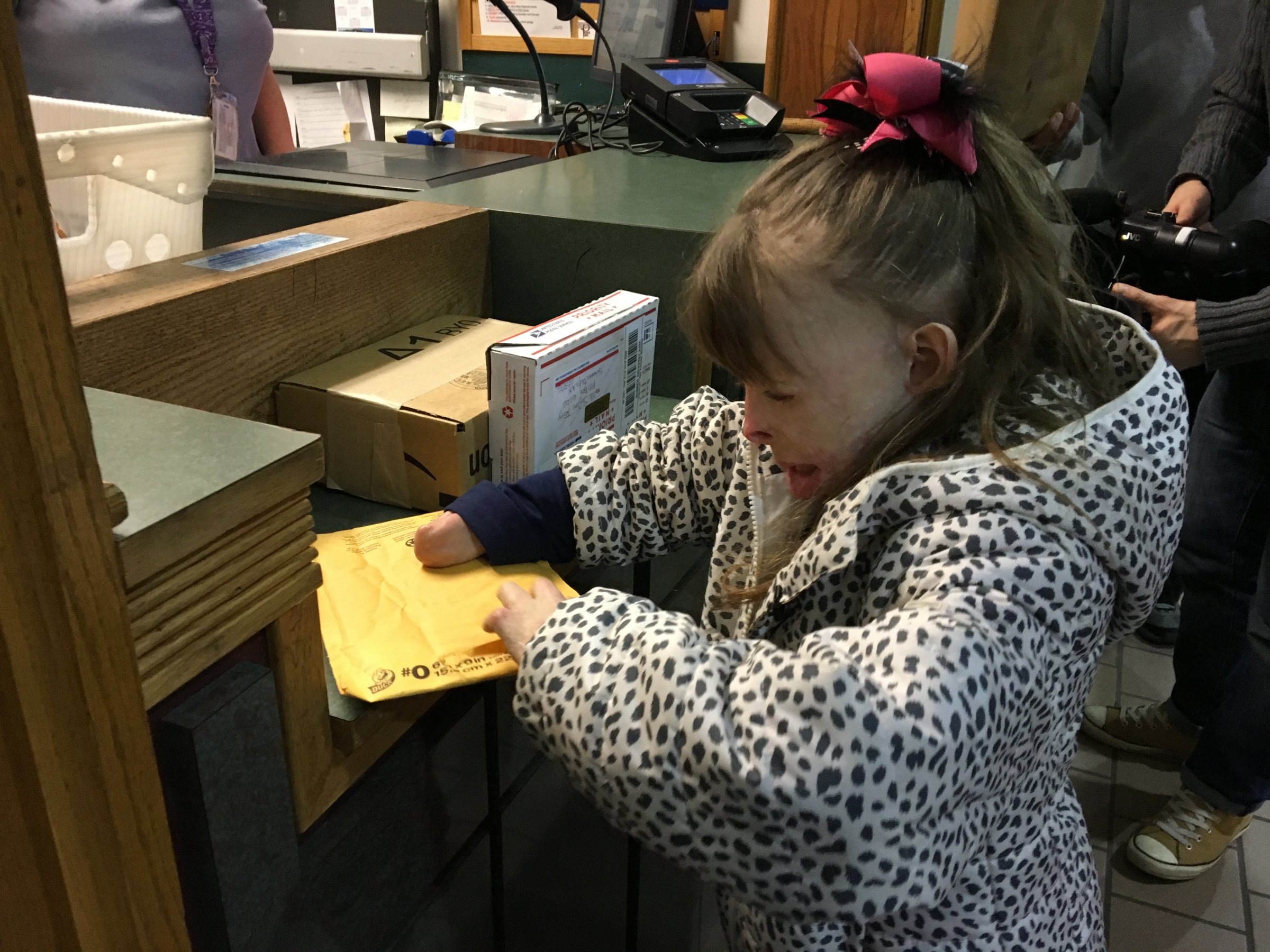 Safyre Terry opens a gift at a post office near her home in Rotterdam, NY.