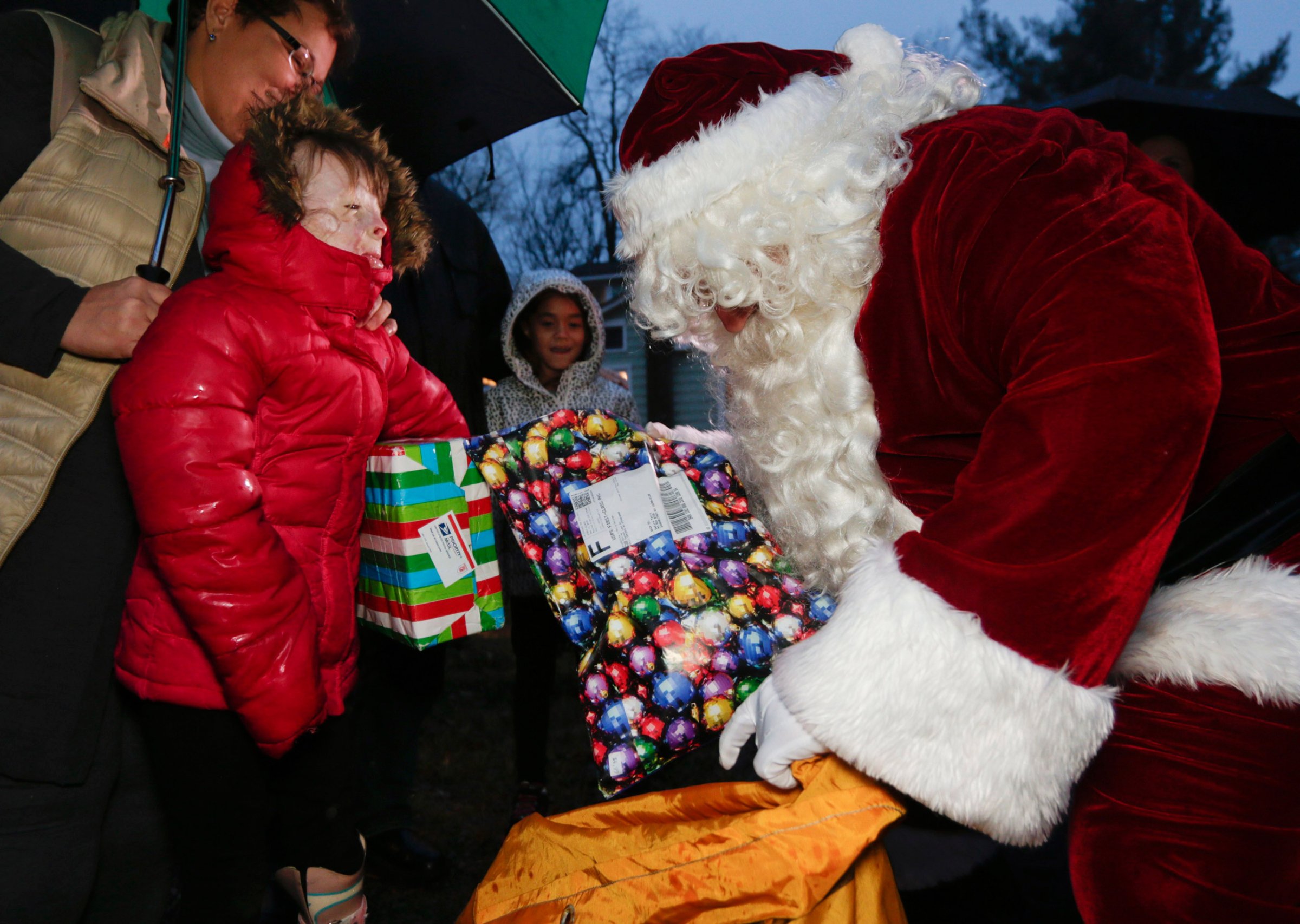 FILE - In this Dec. 17, 2015, file photo, Safyre Terry receives packages from Santa Claus in Rotterdam, N.Y. Terry, who lost her father and siblings in an arson fire that left her severely scarred is sharing the good cheer bestowed on her by the truckload since her simple Christmas wish went viral. (AP Photo/Mike Groll, File)