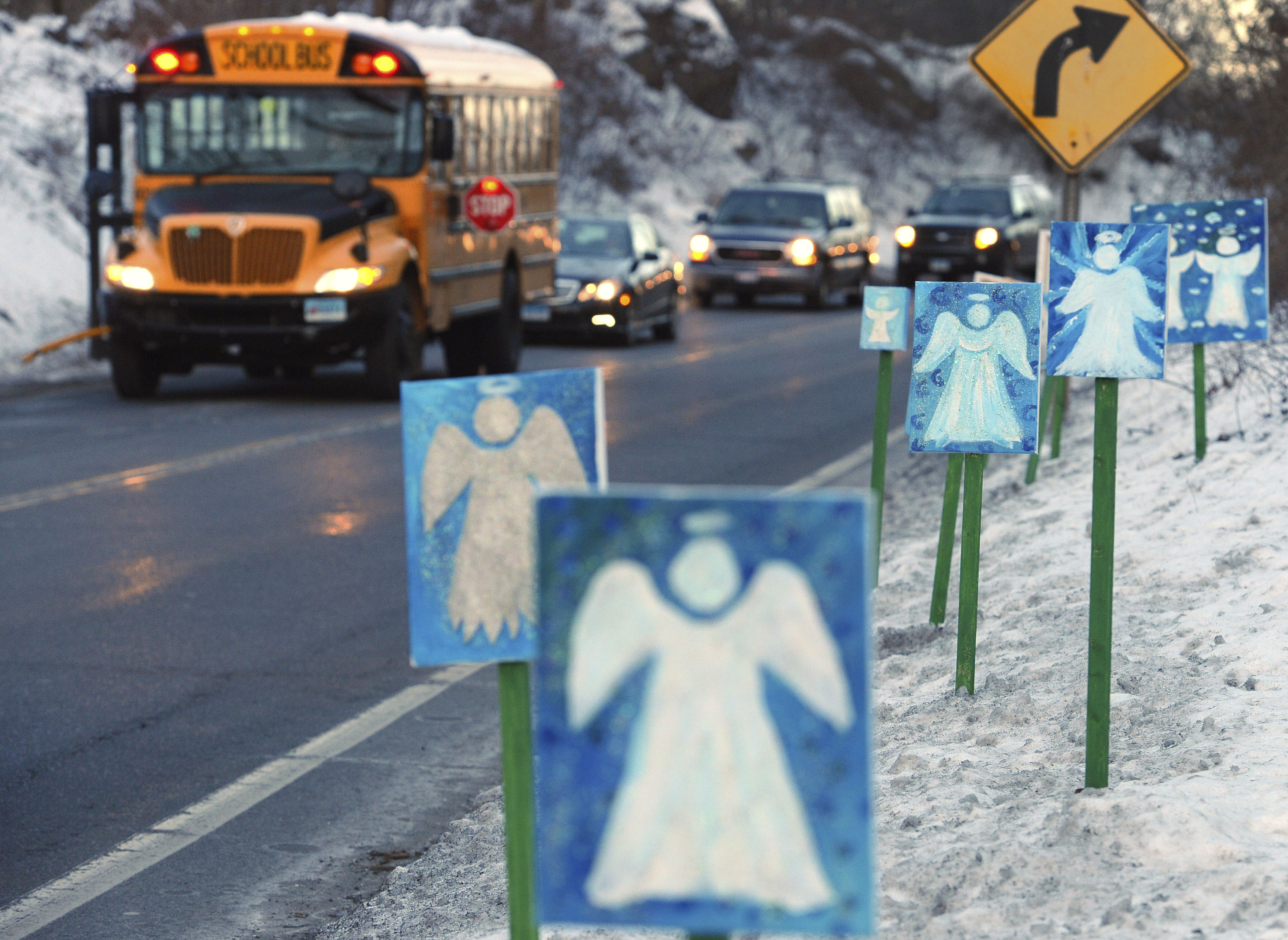 A bus traveling from Newtown, Conn., to Monroe stops near 26 angel signs posted along the roadside in Monroe, Conn., on Jan. 3, 2013, the first day of classes for Sandy Hook Elementary School students since the Dec. 14, 2012, shooting. (Jessica Hill—AP)