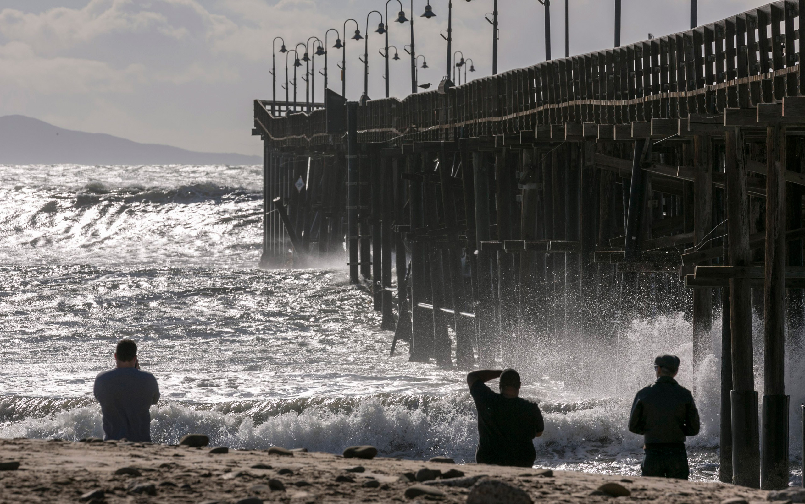 Rough seas surge over the Ventura Pier in Ventura, Calif., on Friday, Dec. 11, 2015. Surging waves inundated several low-lying streets along the coast as a very large Pacific swell hit Friday. (AP Photo/Damian Dovarganes)