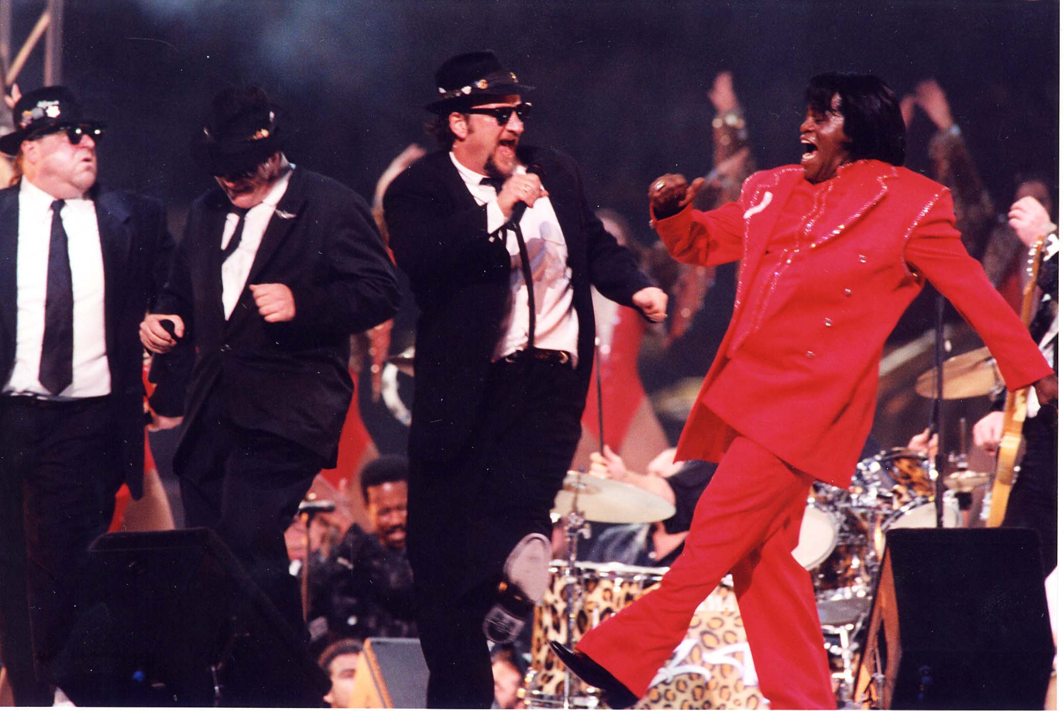 From left: John Goodman, Dan Aykroyd, and Jim Belushi of The Blues Brothers perform with James Brown during Super Bowl XXXI on Sept. 6, 1997 in New Orleans.