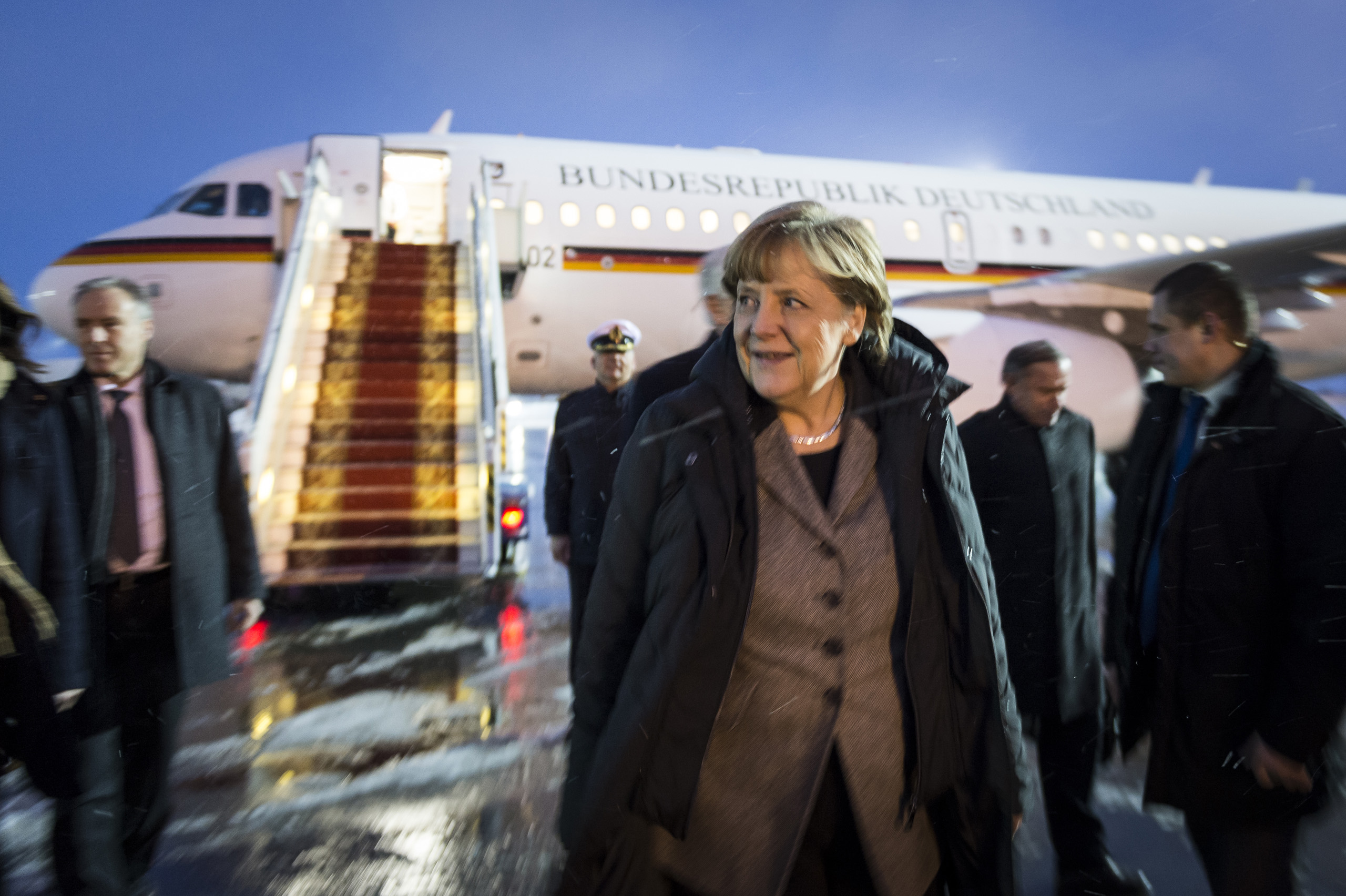 Chancellor Angela Merkel leaves the plane at the airport of Kiev, after arriving for another round of negotiations with the presidents of France, Ukraine and Russia to settle the conflict in Ukraine. Feb. 5, 2015.