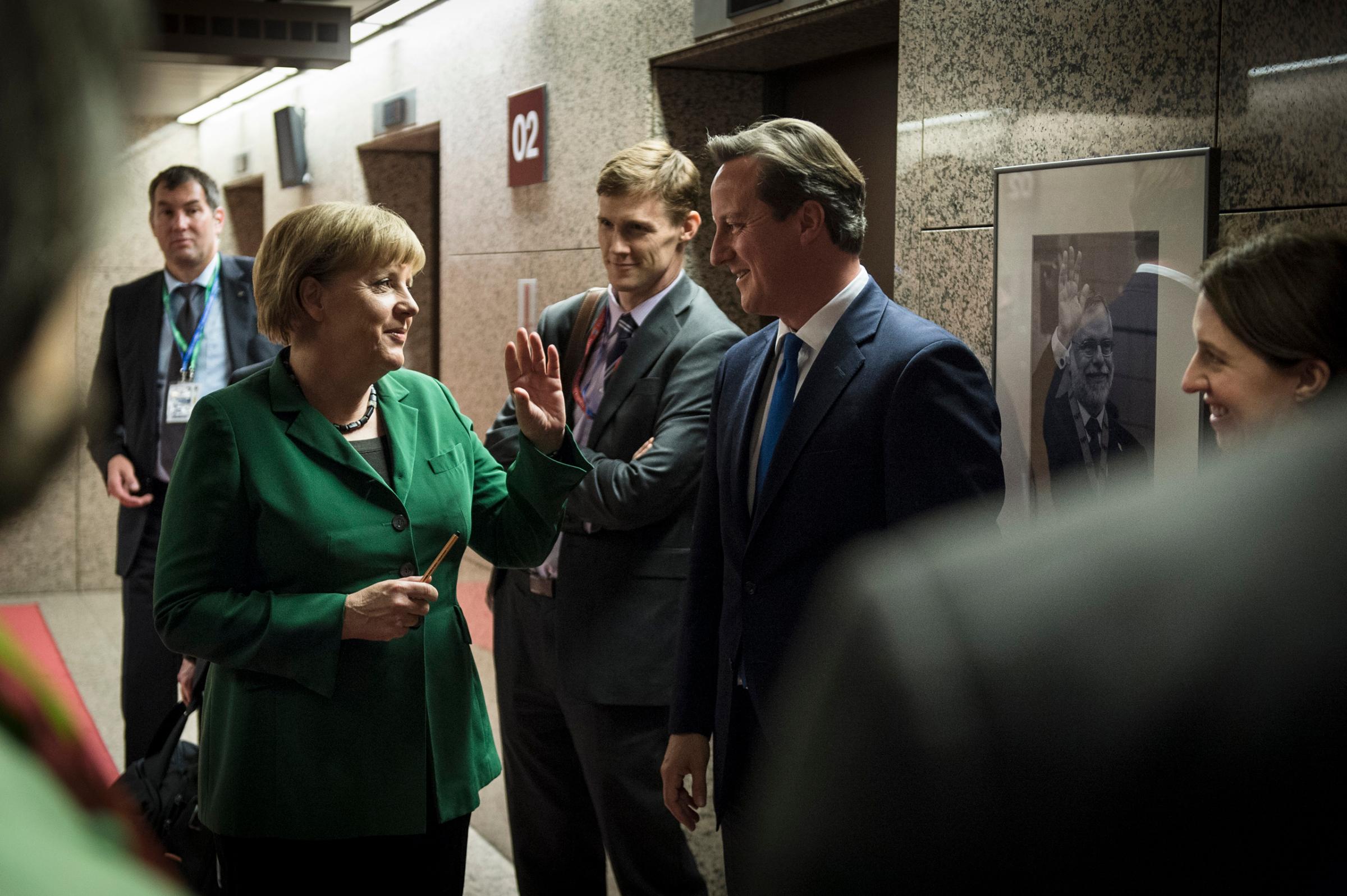 Chancellor Merkel and British Prime Minister David Cameron joke as they wait for their elevators after a European Council meeting in Brussels. Oct. 19, 2012.