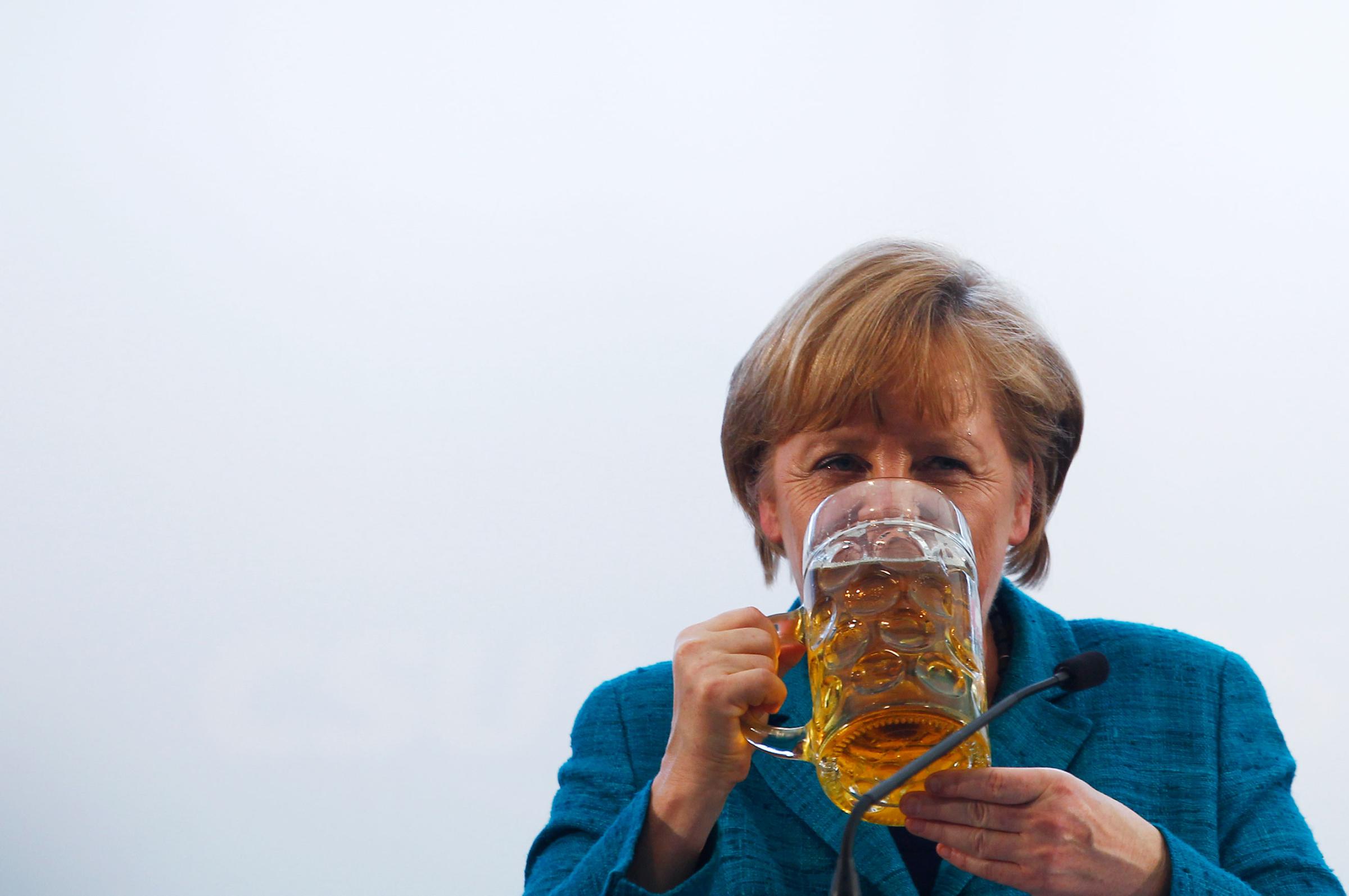 Chancellor Angela Merkel drinks a beer after her speech in a beer tent in Munich on May 15, 2013.