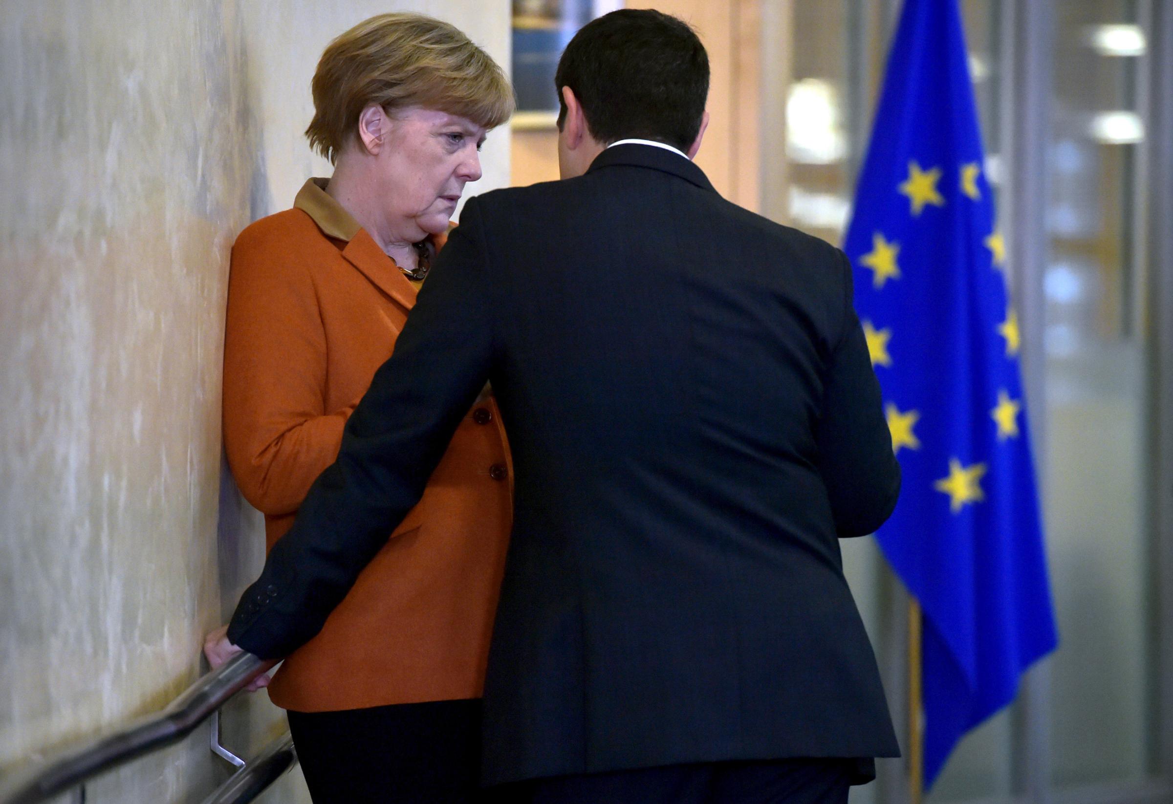 Greece's Prime Minister Alexis Tsipras talks with Germany's Chancellor Angela Merkel prior to a meeting over the Balkan refugee crisis with leaders from central and eastern Europe at the EU Commission headquarters in Brussels on Oct. 25, 2015.