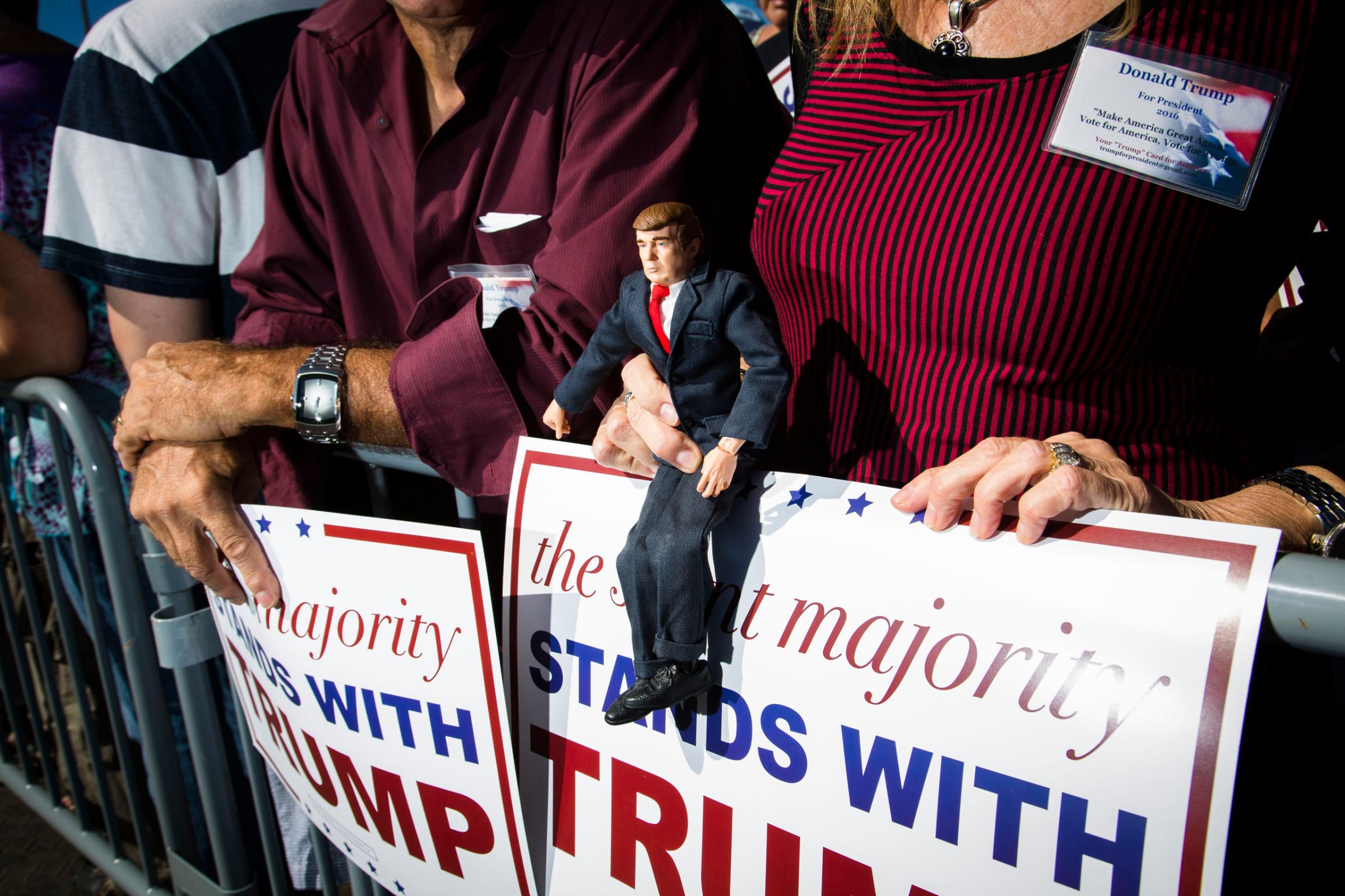 Supporter of Republican presidential candidate Donald Trump holds up a doll in the likeness of Trump at a rally in Sarasota, Fla. Nov. 28, 2015.