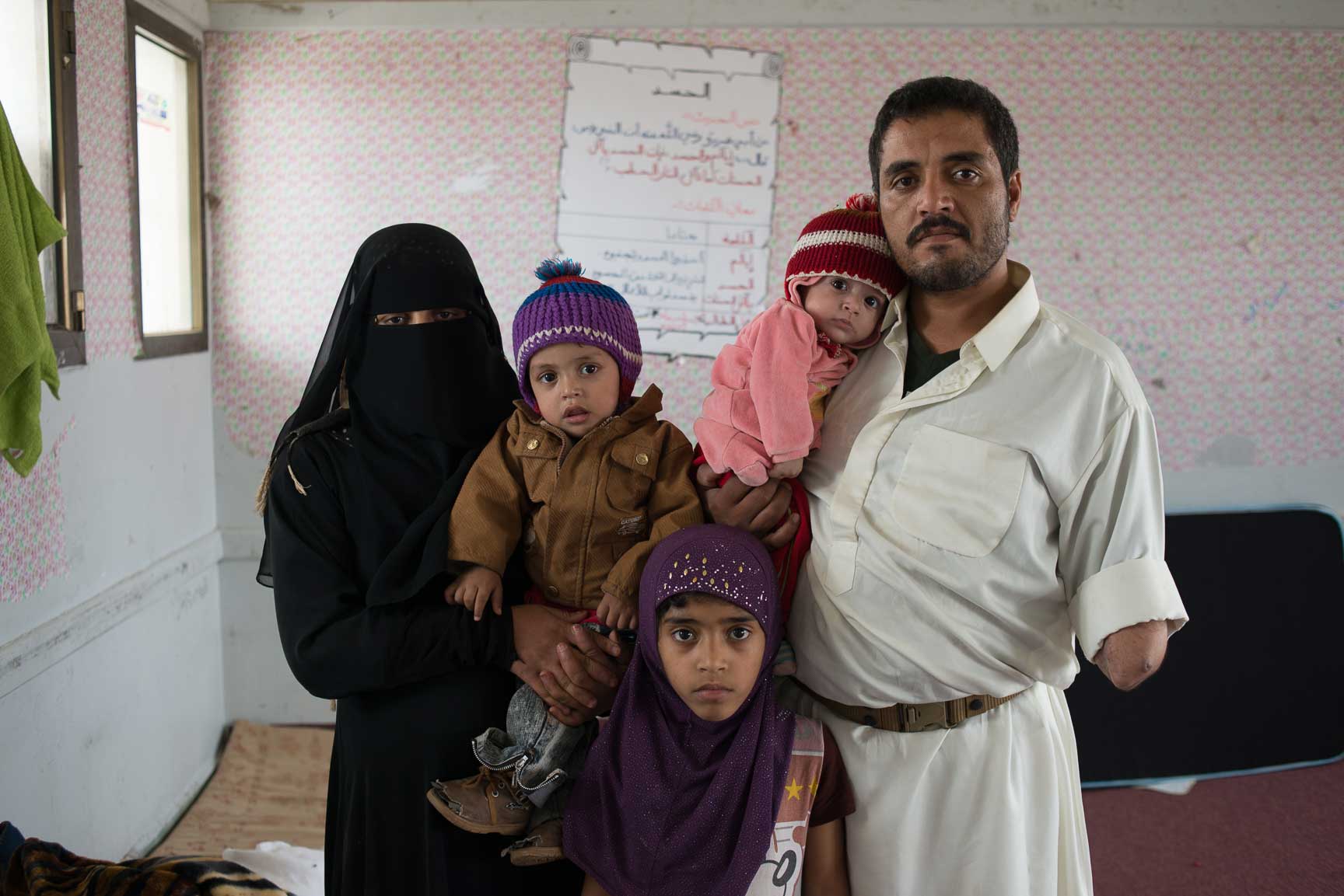 Mohammad Abdulrab Qahed, originally from the Razih district of Sa'ada, bordering Saudi Arabia, stands with his wife Umm Sa'ad, and three children, Imad, Wiam, and Dua'a, on June 10, 2015 in Sana'a, Yemen. Now living in a school with other IDP's, they are some of the 1.5 million Yemenis displaced from their homes across the country.
