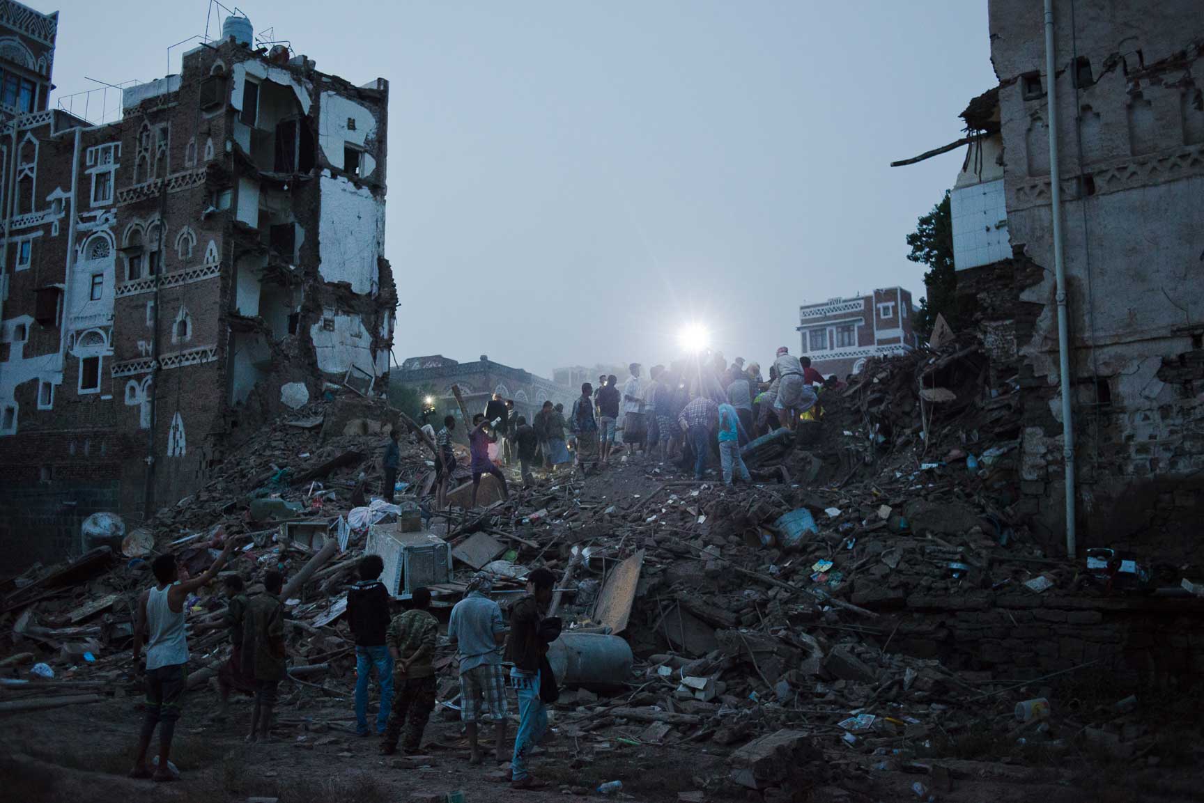 Yemeni men from al Qasimi neighborhood dig through the remains of four homes destroyed in an airstrike Friday, June 12, 2015 in Sana'a, Yemen. The Old City of Sana'a is a UNESCO World Heritage Site, is a densely populated civilian area. The Saudi-led coalition denied hitting the Old City.