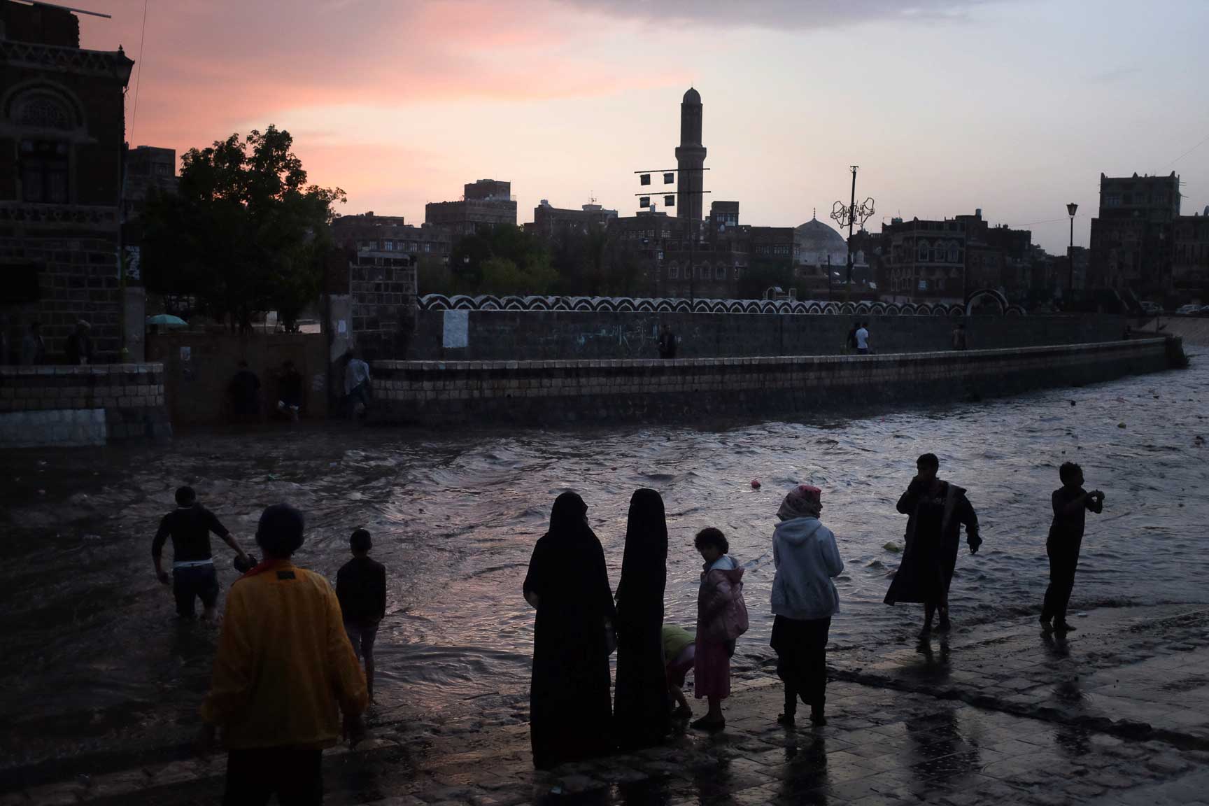 Yemeni children play in the Silah drainage road after heavy rains on August 6, 2015 in Sana'a, Yemen.