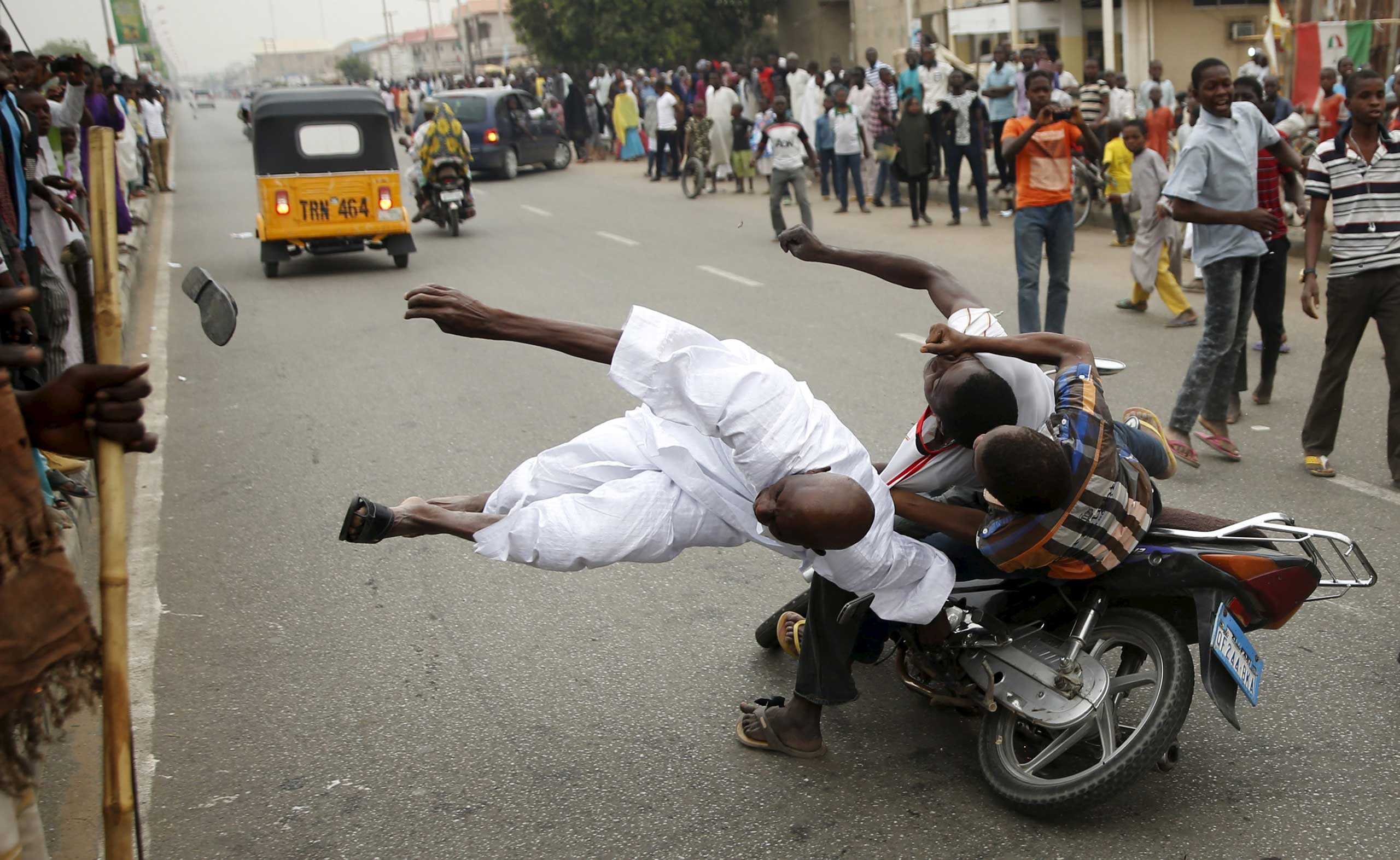 Goran Tomasevic: 
                               I was in Kano, northern Nigeria, on assignment covering the presidential elections. When the results were announced of Muhammadu Buhari’s victory, large crowds started celebrating on the streets.
                              The man in the picture was accidentally hit by a motorcyclist driving at full speed as he was standing by the side of the road. He fell to the ground and didn’t move or respond to others. He was quickly driven to a hospital. I think he died but I am not sure. 
                              I felt very sorry for this man. He was in the streets clearly celebrating a very important moment for him when this happened. 
                              
                              This photo was taken in Kano on March 31, 2015.