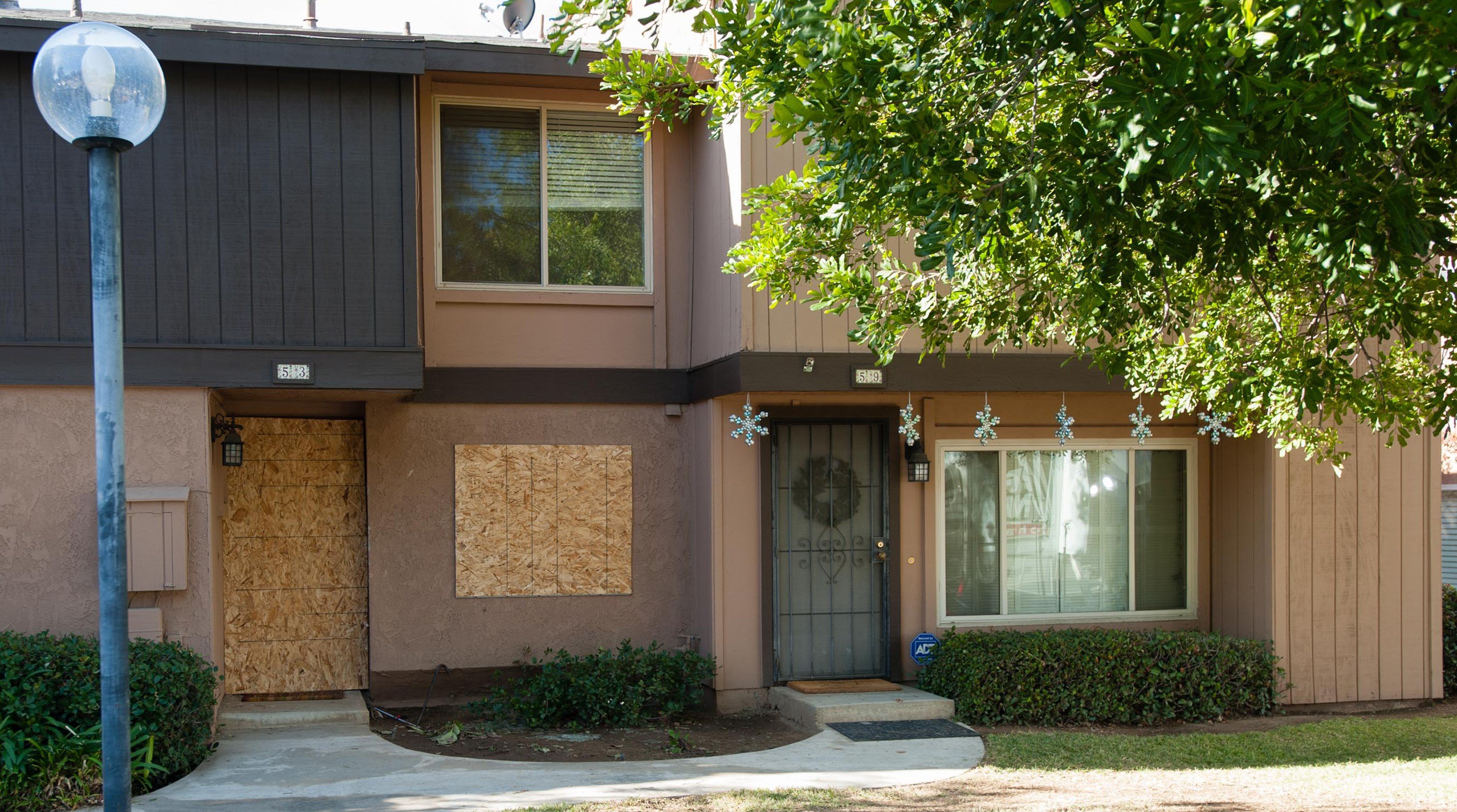 The rented Center Street townhouse of Syed Rizwan Farook and his wife, Tashfeen Malik, is boarded up as holiday decorations and a wreath adorn a neighboring residence on December 5, 2015, in Redlands, CA. (Greg Vojtko—AFP/Getty Images)