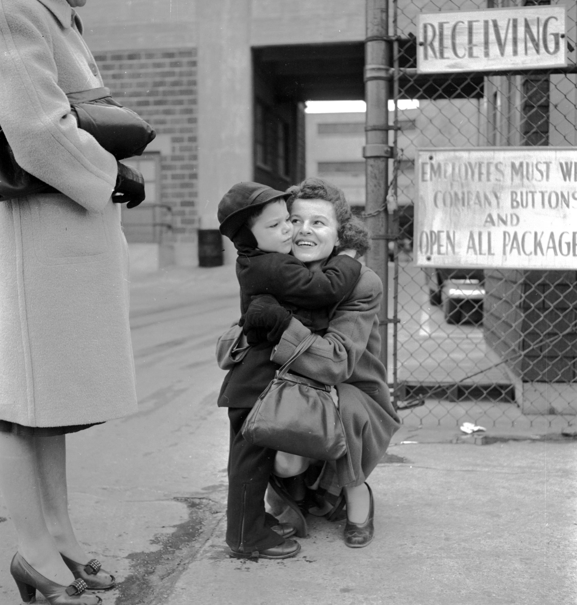 A mother hugging her son goodbye, 1947.
