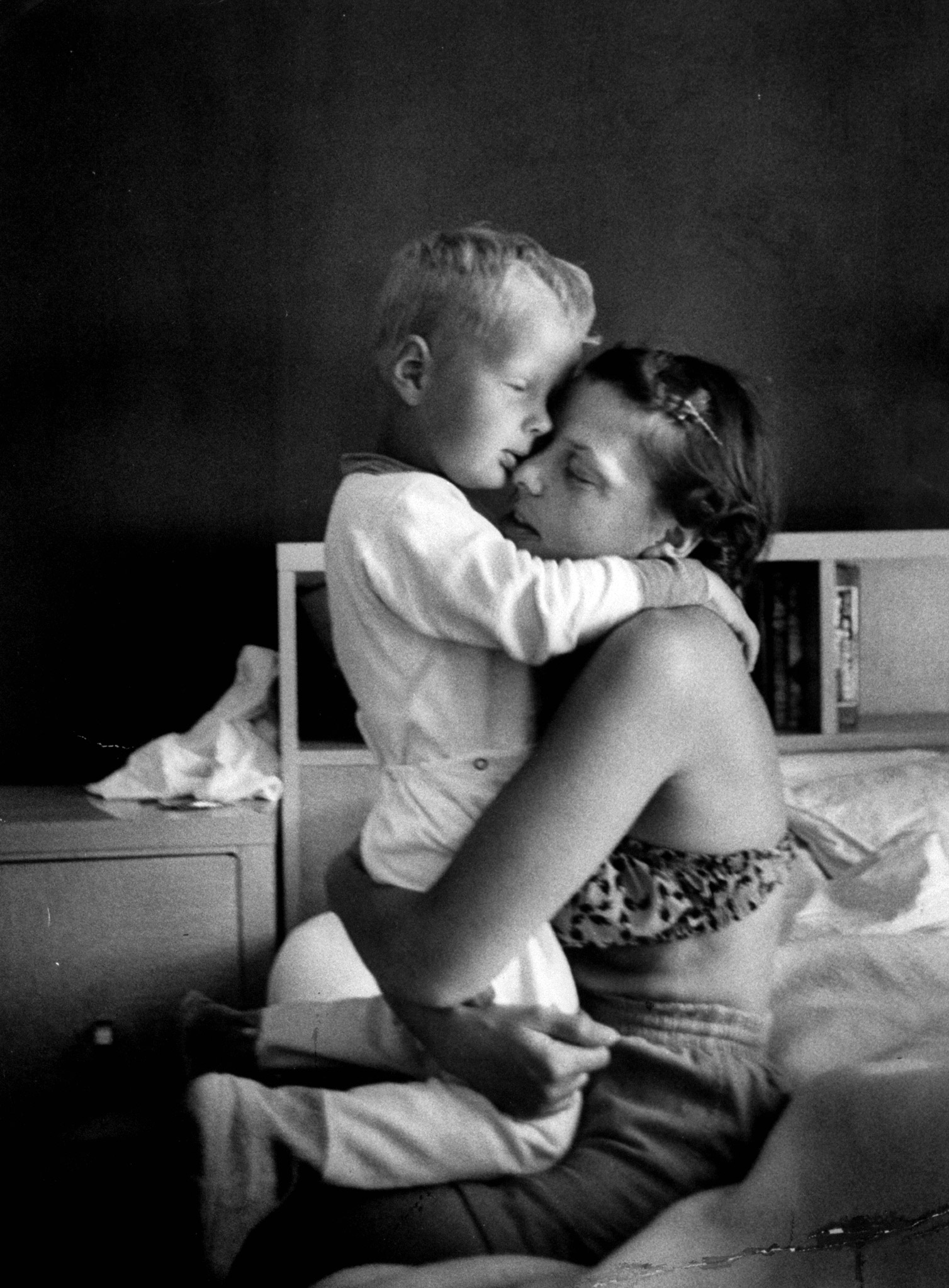Young mother hugging one of her sons, 1955.