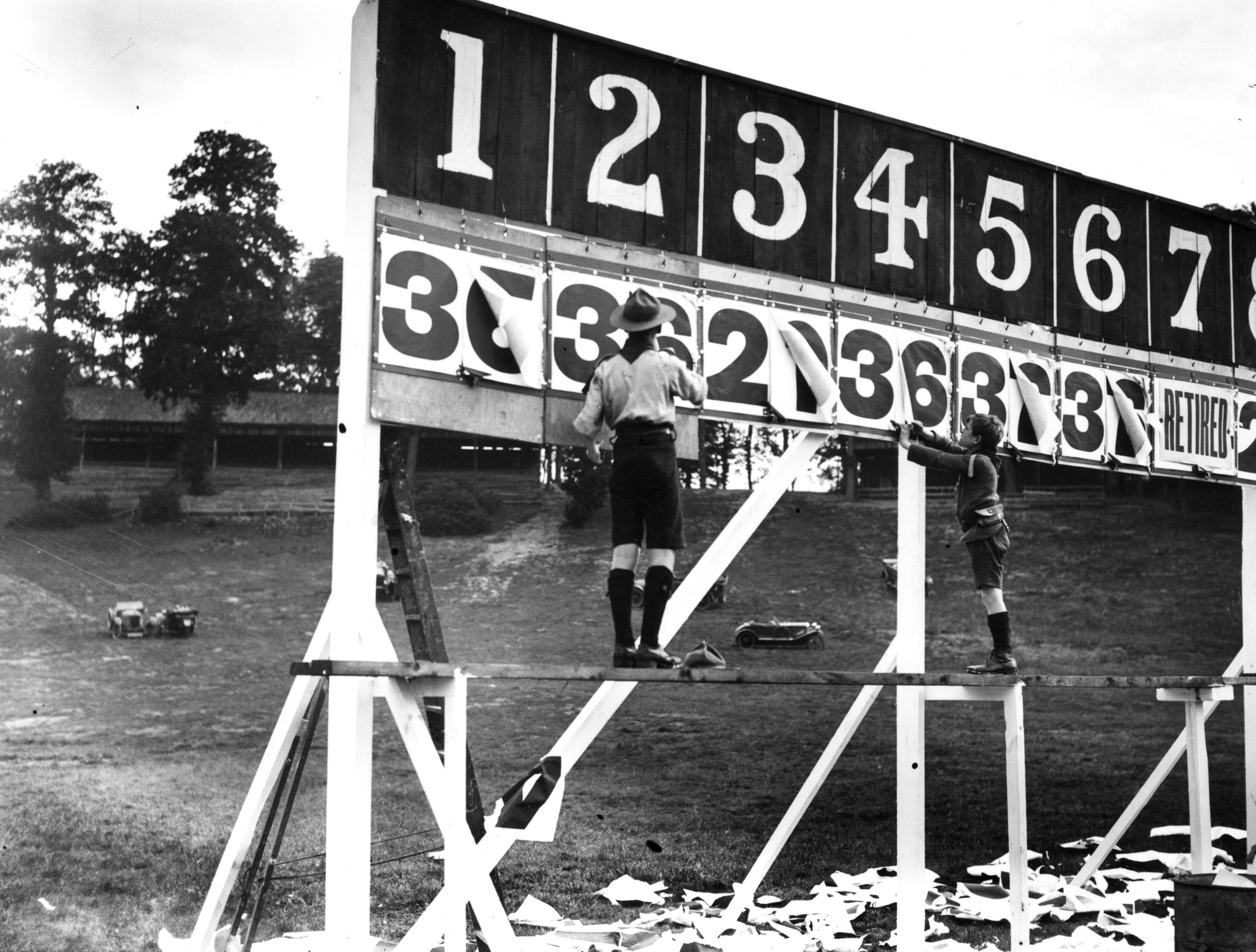 Scouts tearing the sheets of 'laps to go' off the scoreboard for the Junior Car 250 Mile Race at Brooklands.  August 1922.