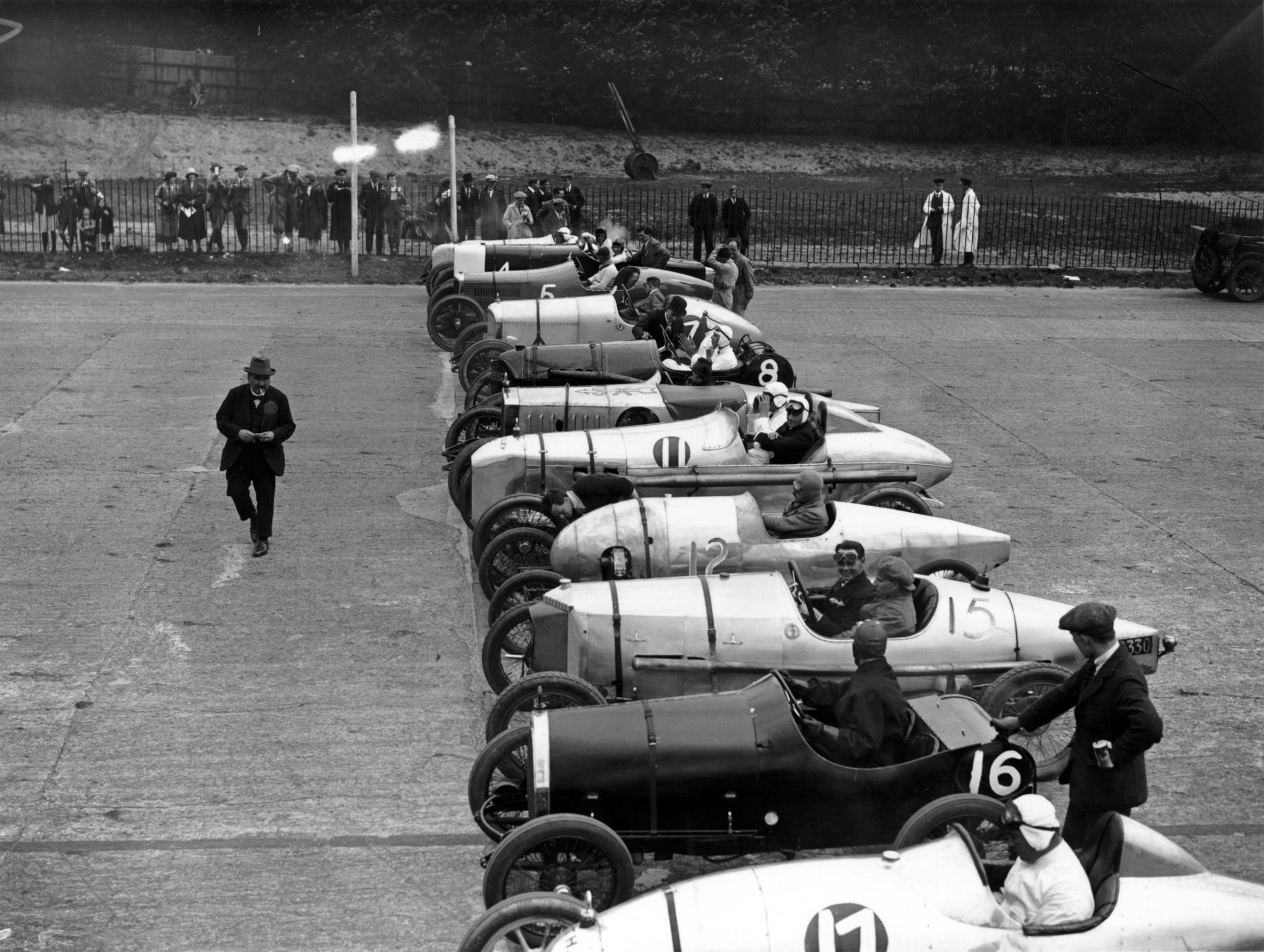 Cars lined up at the starting line for the 3-lap 100 mph Long Handicap race at the Brooklands Whitsun meeting.