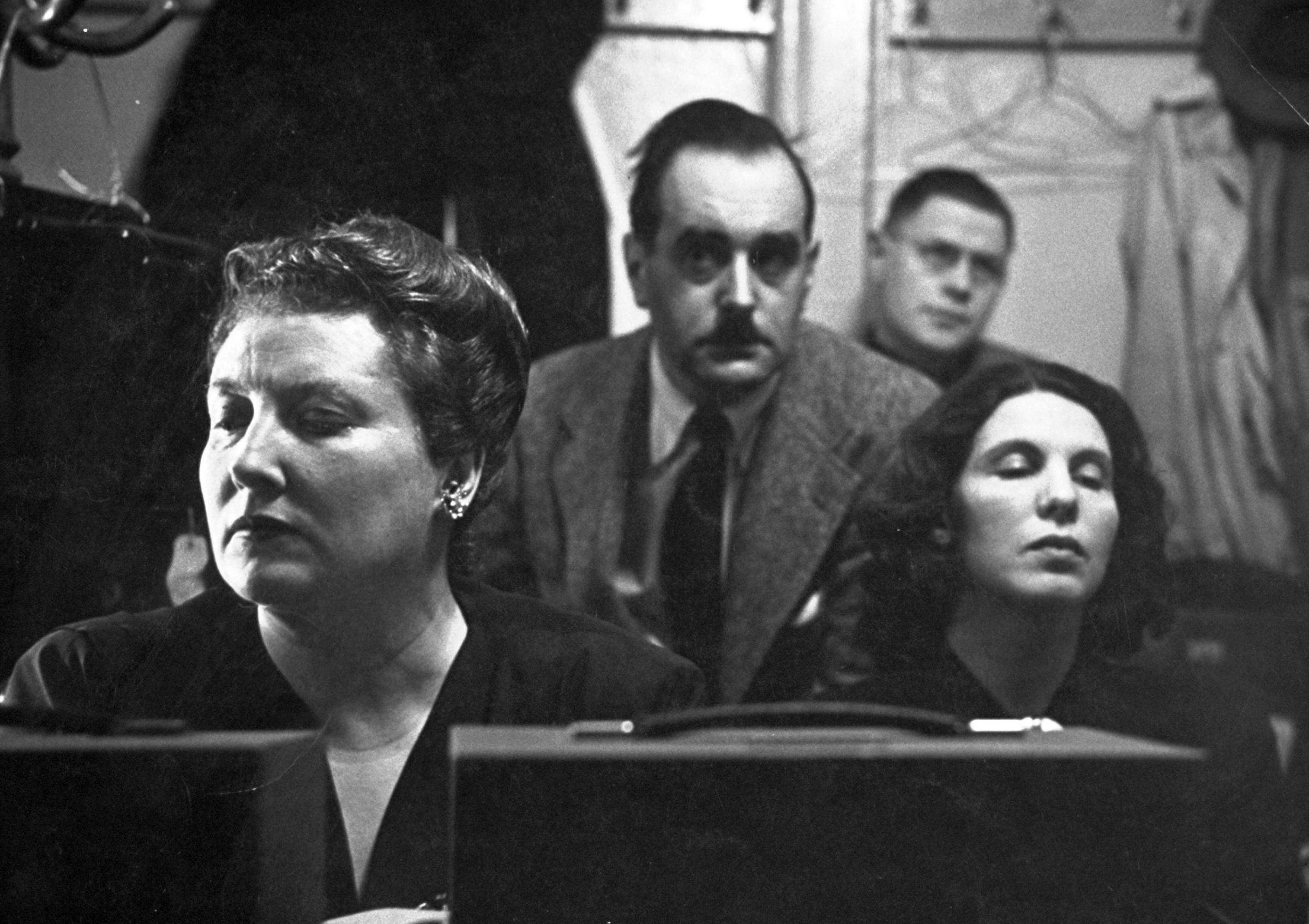 Eyes closed and their faces mask-like in deep reverie, Helen Traubel (left) and Herta Glaz (right) sit in recording booth with sound engineers listening to their duet from Tristan.