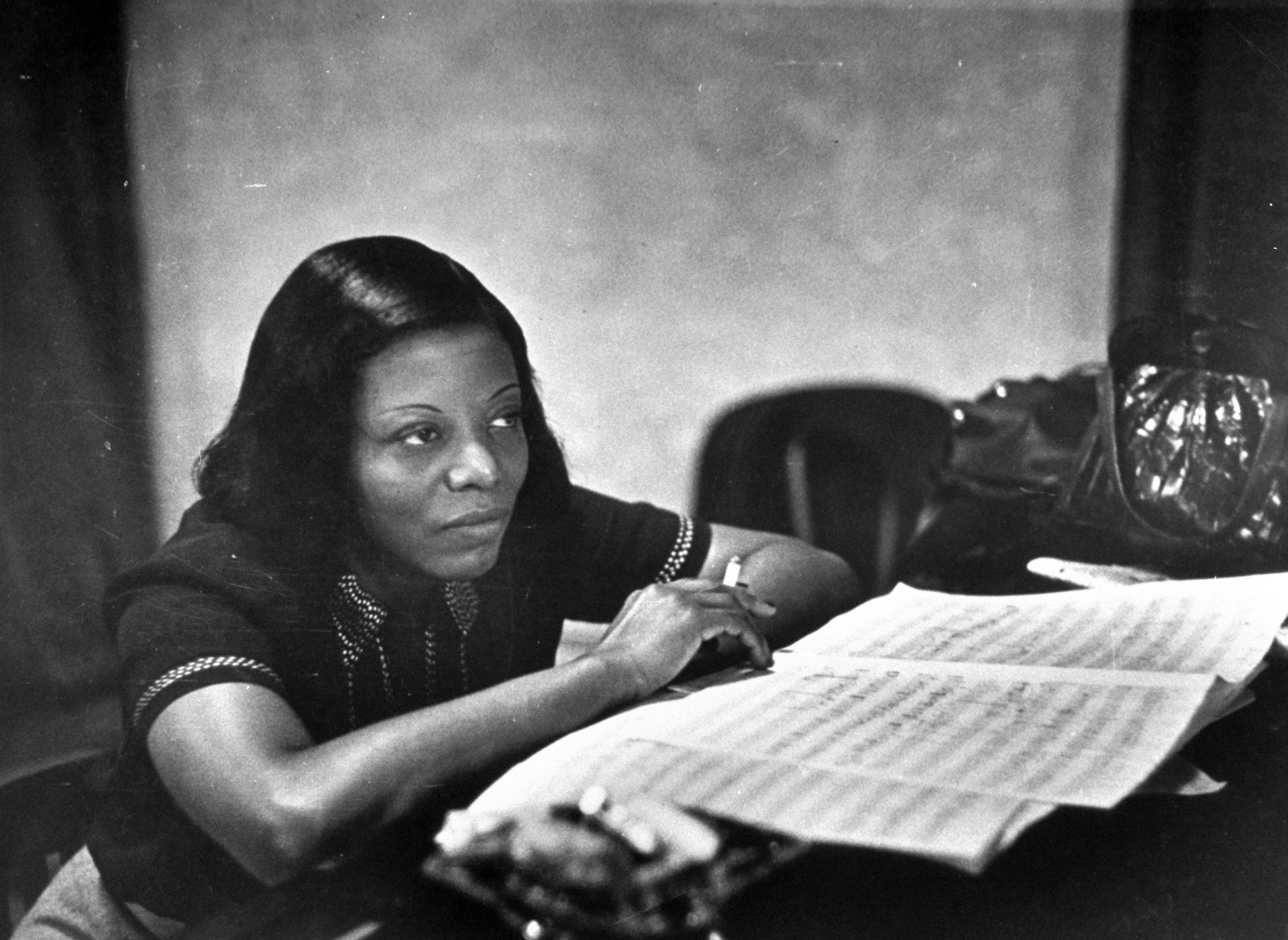 Jazz musician Mary Lou Williams, music in front of her, listening to playback of recording she has just made.