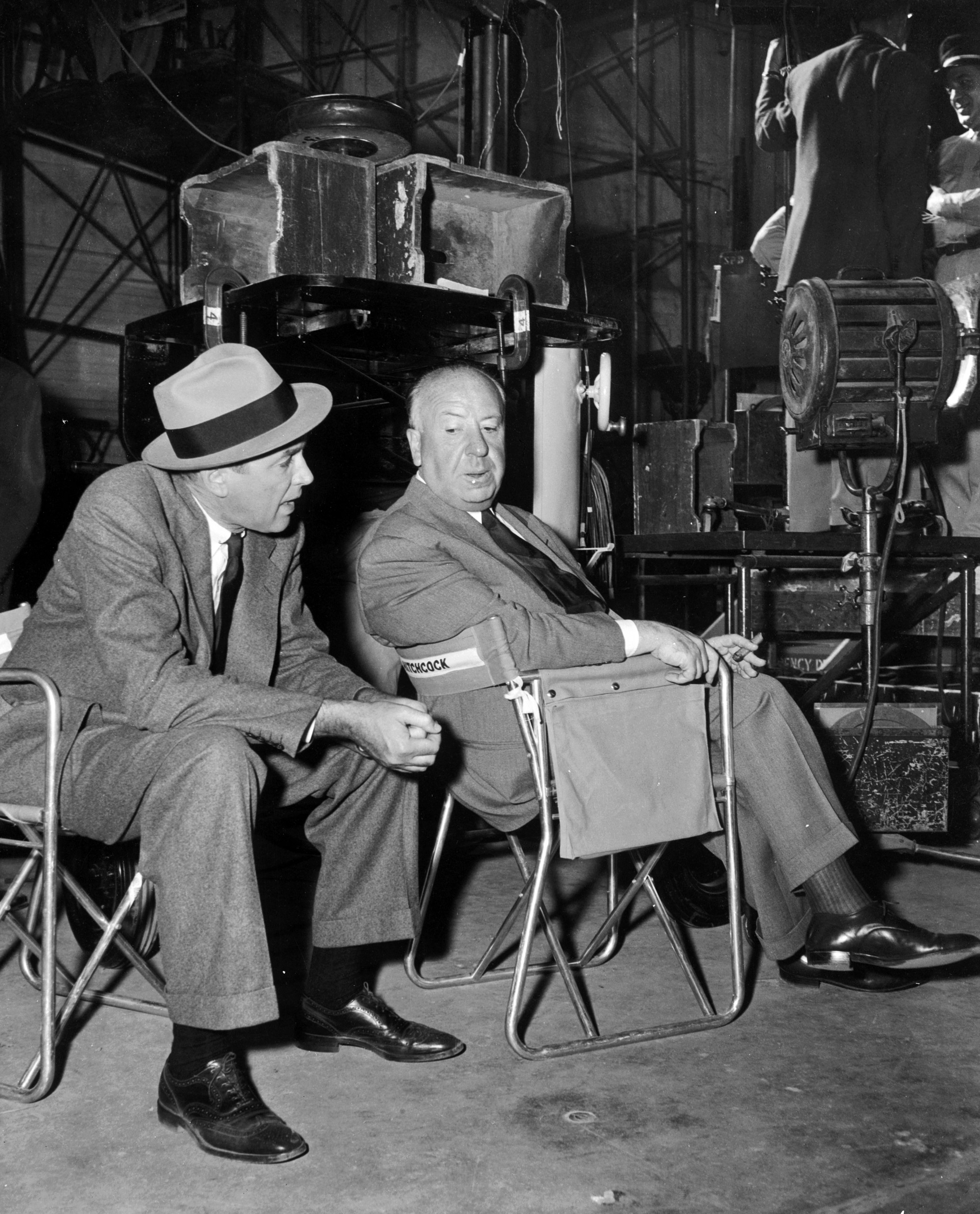Alfred Hitchcock sitting with James Stewart on the set of his latest thriller 'The Man Who Knew Too Much'. 1956.