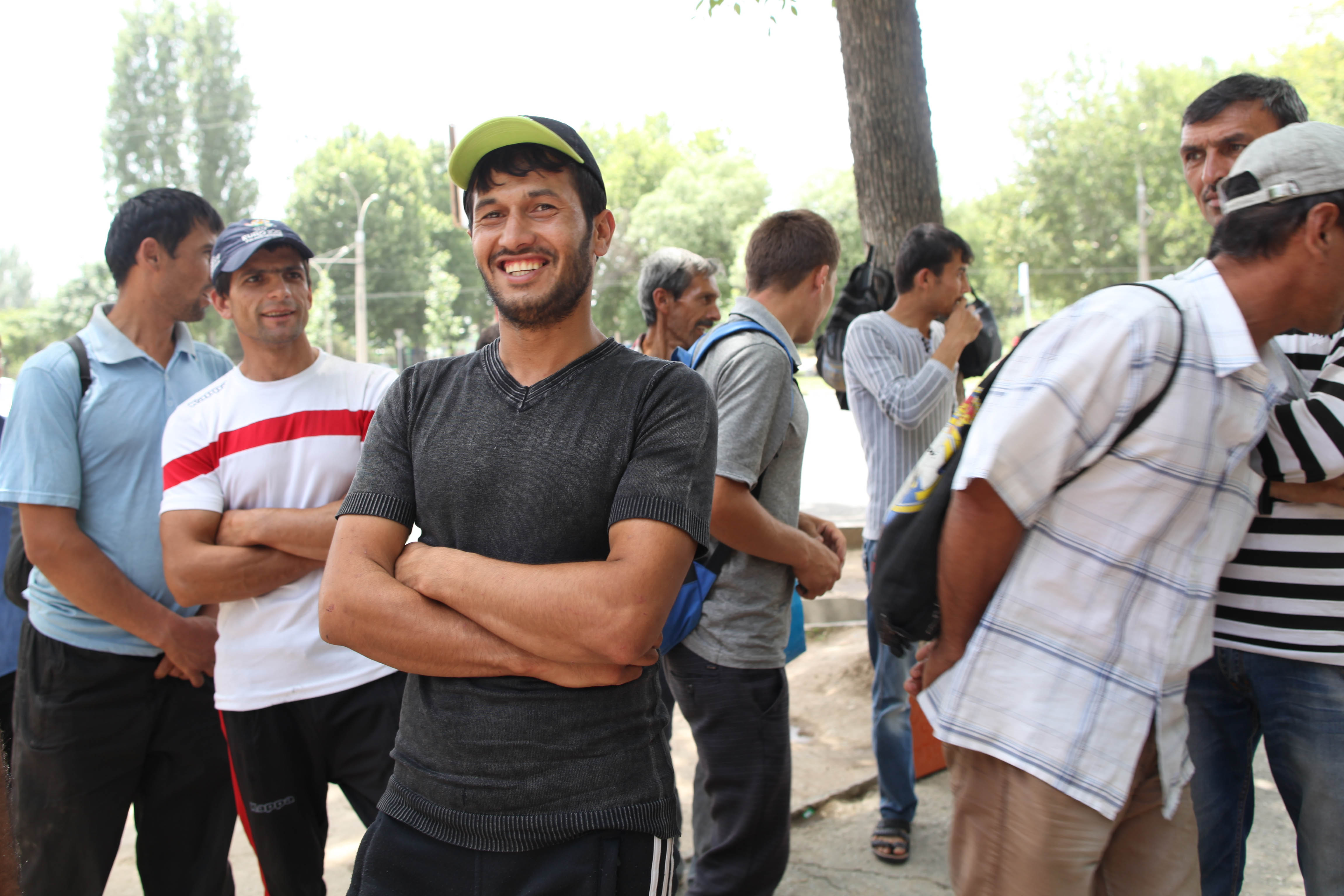 Muhammed Ziyo, 26, a day laborer, poses with other day laborers in the background on a street corner in the 82nd district of Dushanbe, Tajikistan, on June 11, 2015 (The Washington Post/Getty Images)